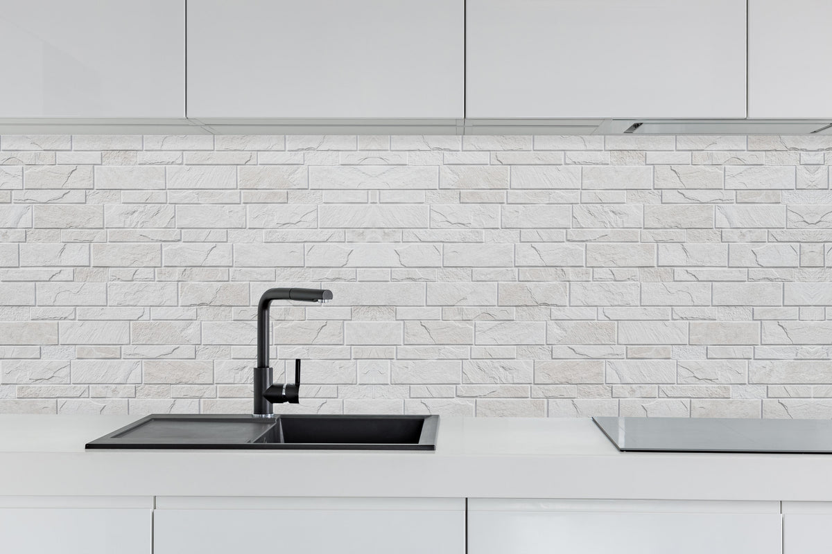Küche - Weiße moderne Steinwand hinter weißen Hochglanz-Küchenregalen und schwarzem Wasserhahn