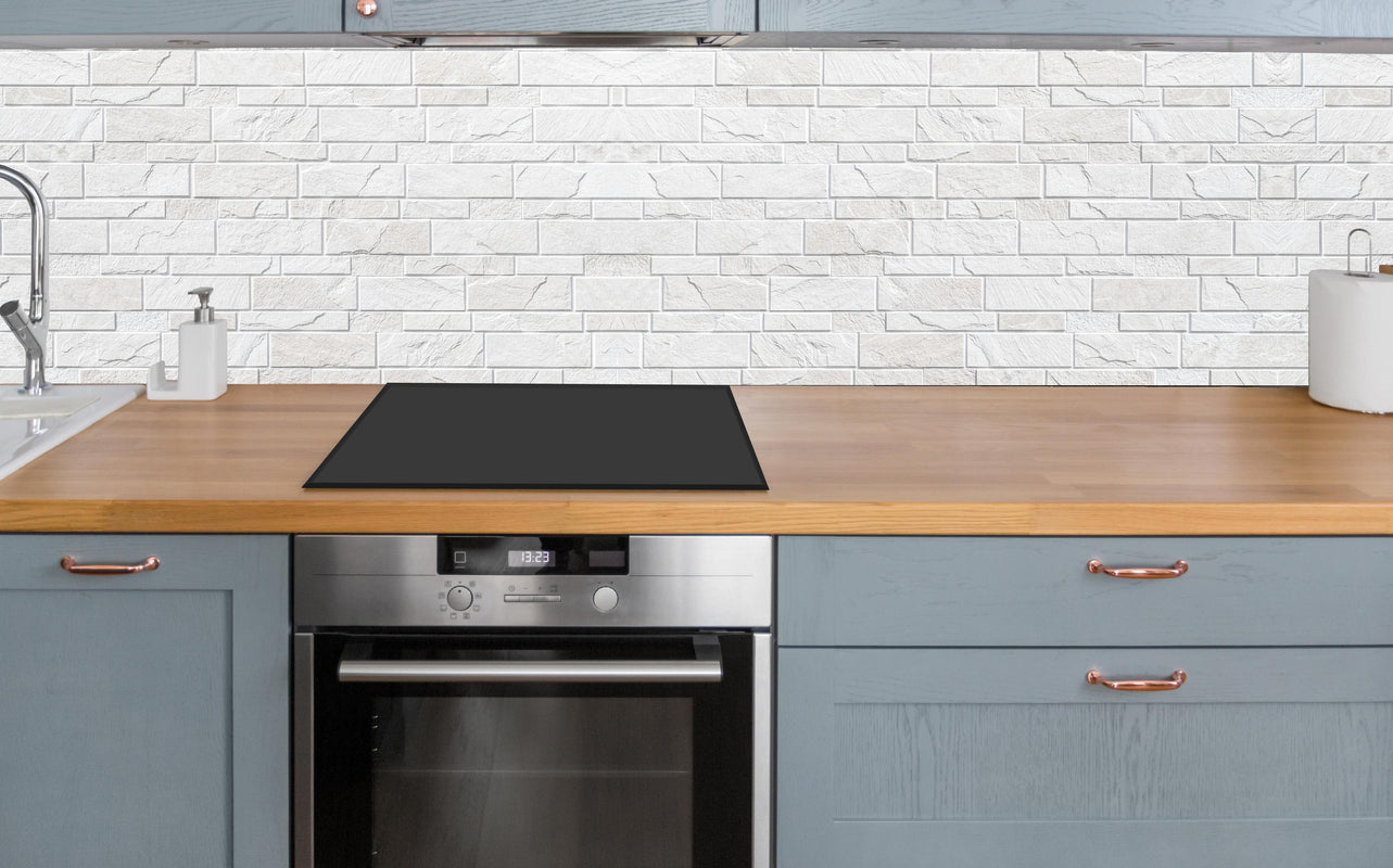 Küche - Weiße moderne Steinwand über polierter Holzarbeitsplatte mit Cerankochfeld