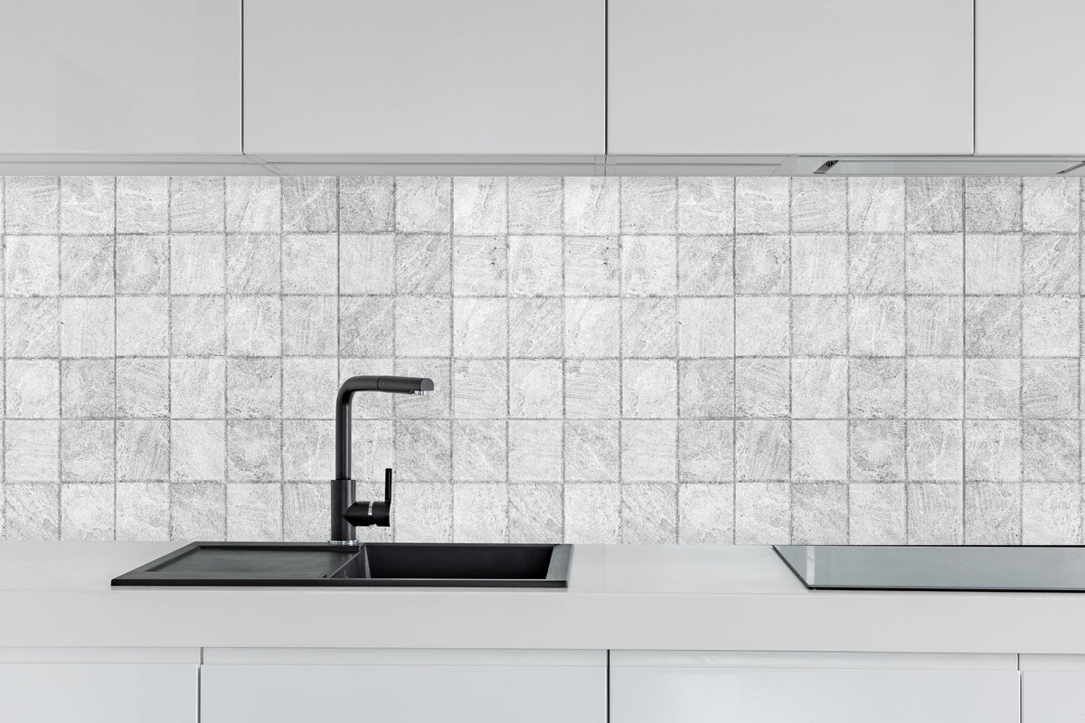 Küche - Weiße quadratische Stein Fliesen hinter weißen Hochglanz-Küchenregalen und schwarzem Wasserhahn