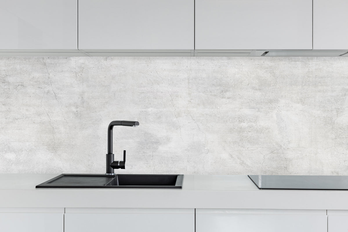 Küche - Weiße rissige Steinwand hinter weißen Hochglanz-Küchenregalen und schwarzem Wasserhahn