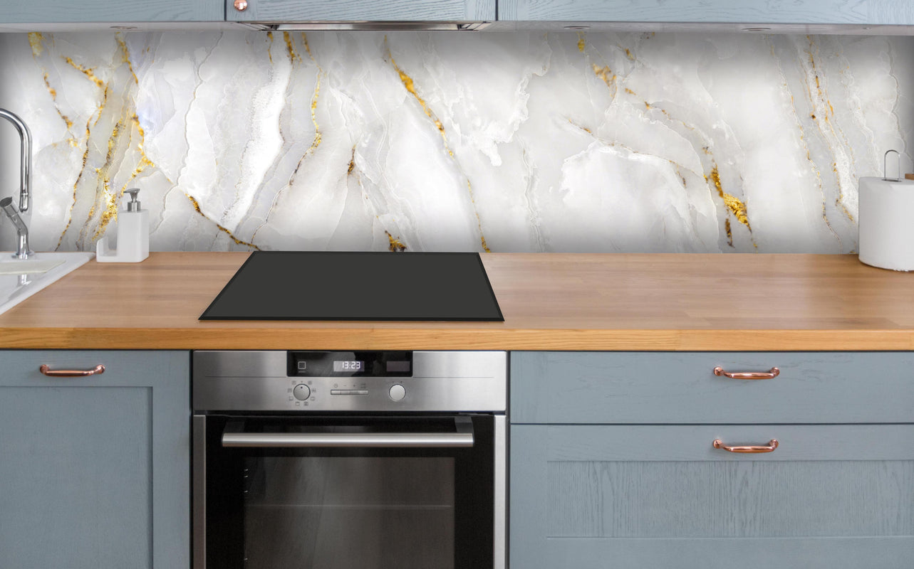 Küche - Weißer Statuario-Marmor mit goldene Adern über polierter Holzarbeitsplatte mit Cerankochfeld