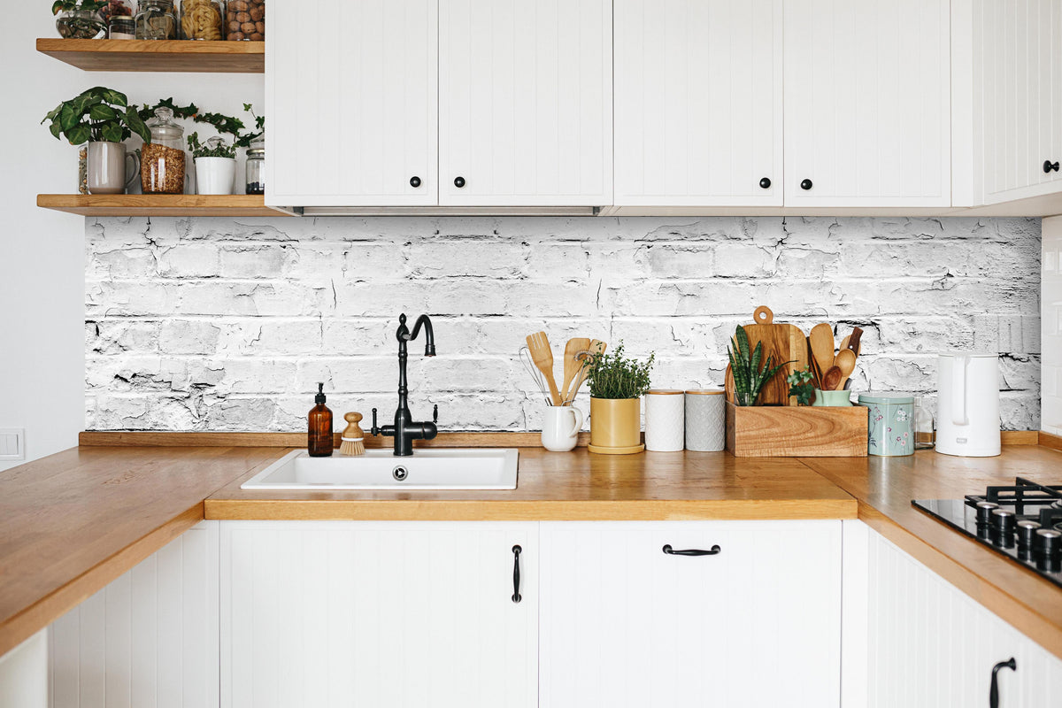 Küche - Weißer rustikaler Mauerwerk in weißer Küche hinter Gewürzen und Kochlöffeln aus Holz