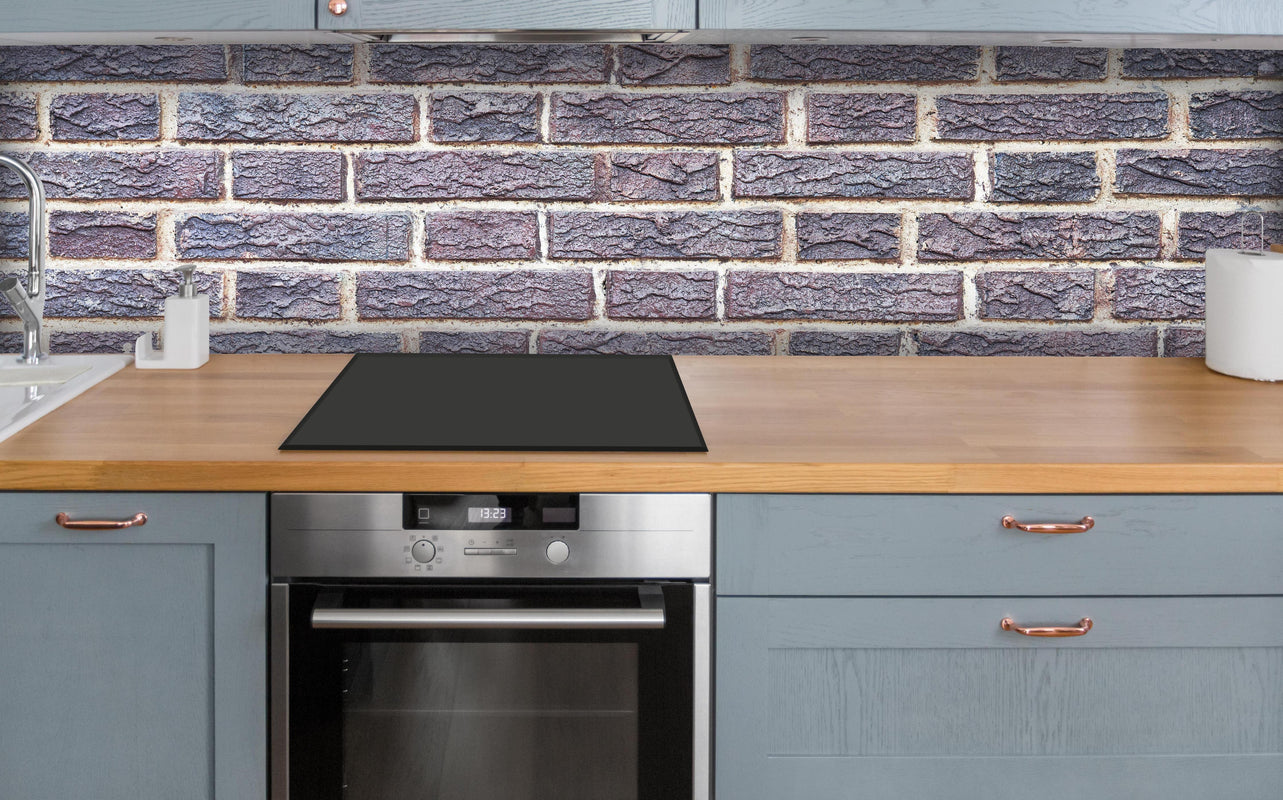 Küche - Zementmauertextur mit rissigen Fliesen über polierter Holzarbeitsplatte mit Cerankochfeld