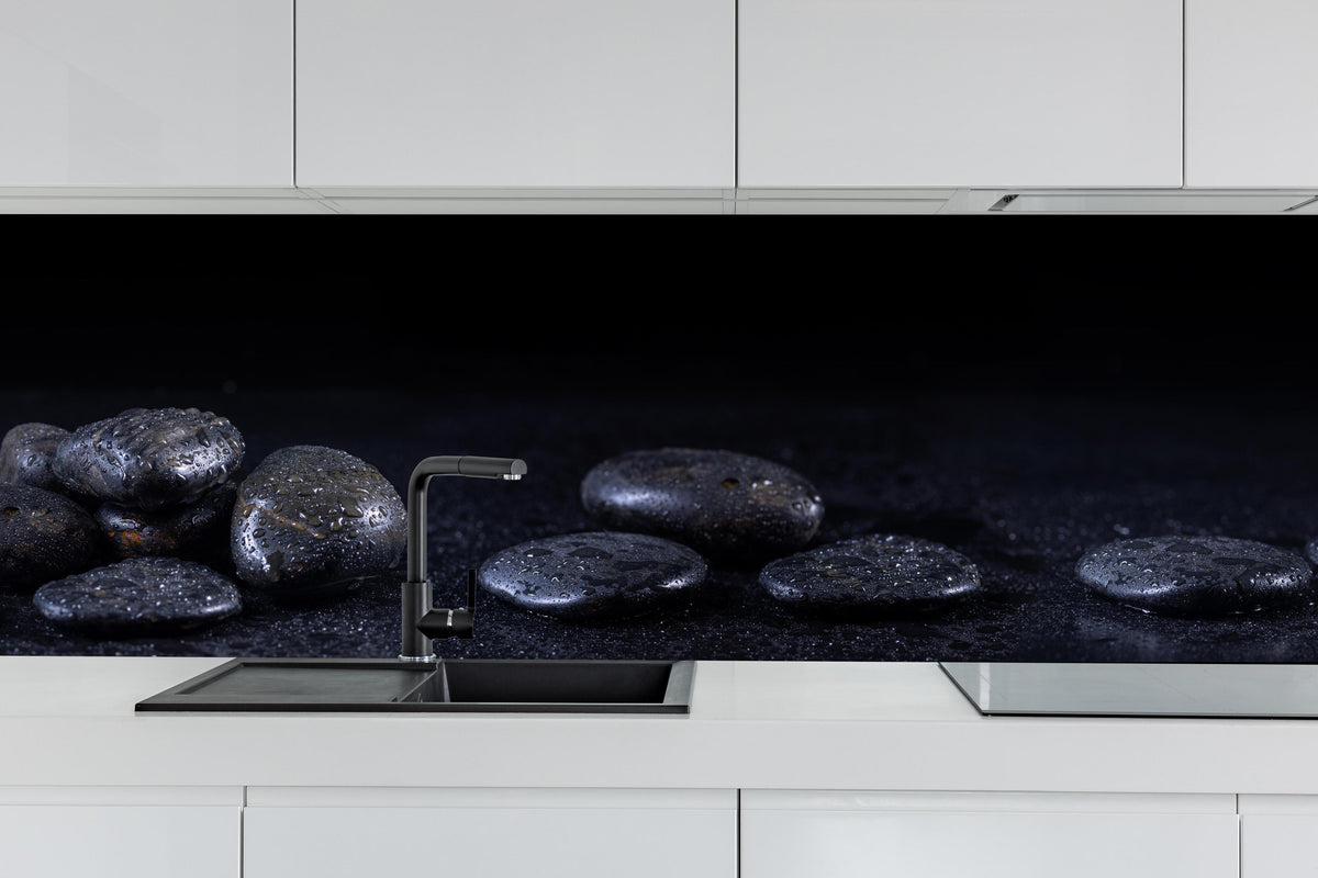 Küche - Zen - Schwarze Steine hinter weißen Hochglanz-Küchenregalen und schwarzem Wasserhahn