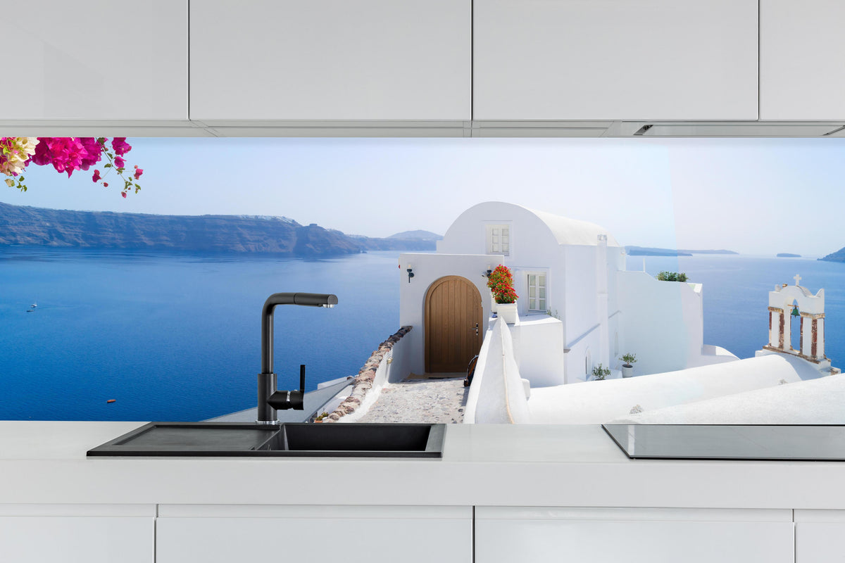 Küche - schöne Details der Insel Santorin hinter weißen Hochglanz-Küchenregalen und schwarzem Wasserhahn