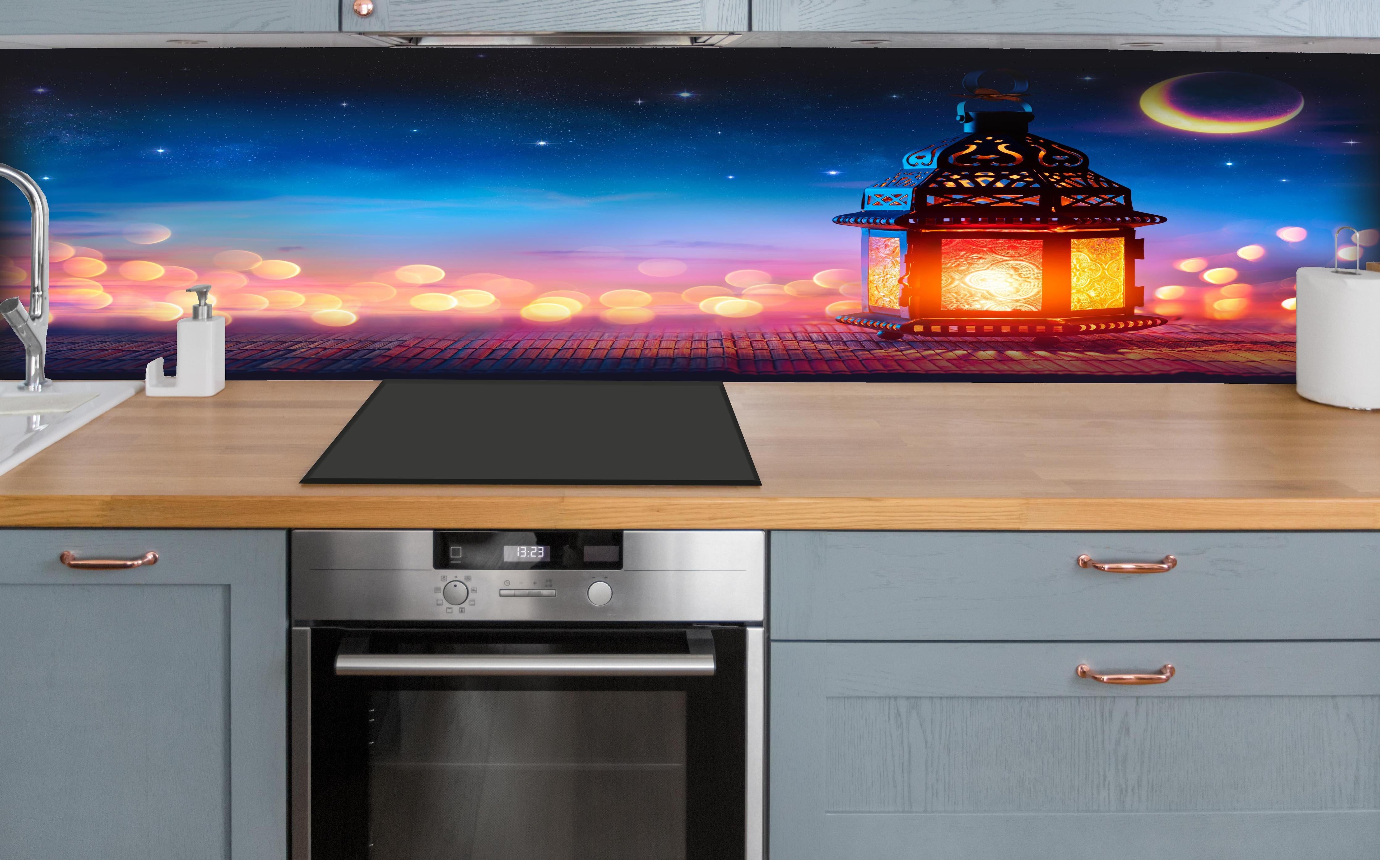 Küche - Laternenlicht bei Sternenhimmel hinter weißen Hochglanz-Küchenregalen und schwarzem Wasserhahn