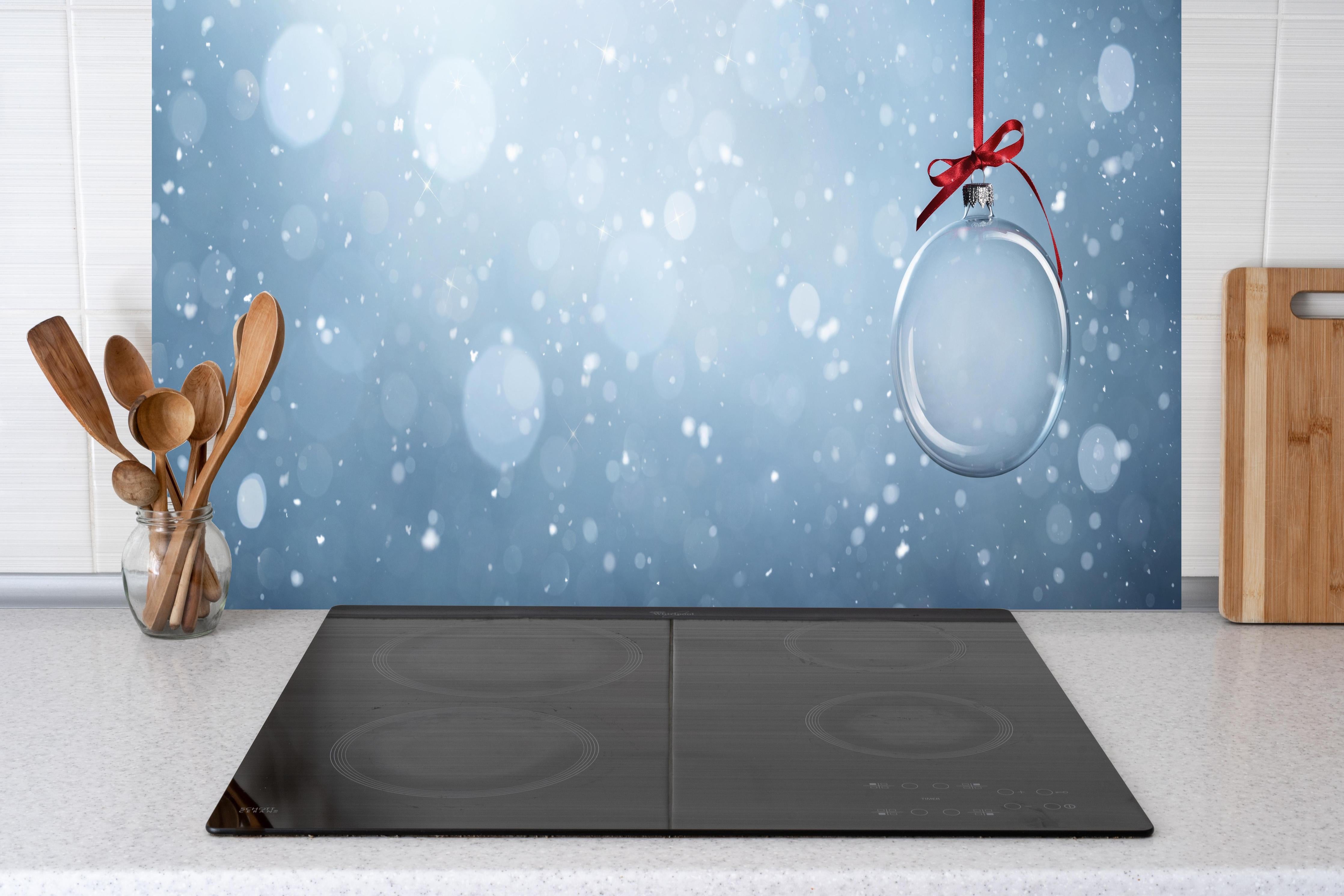 Küche - Leere Weihnachtskugel hinter weißen Hochglanz-Küchenregalen und schwarzem Wasserhahn