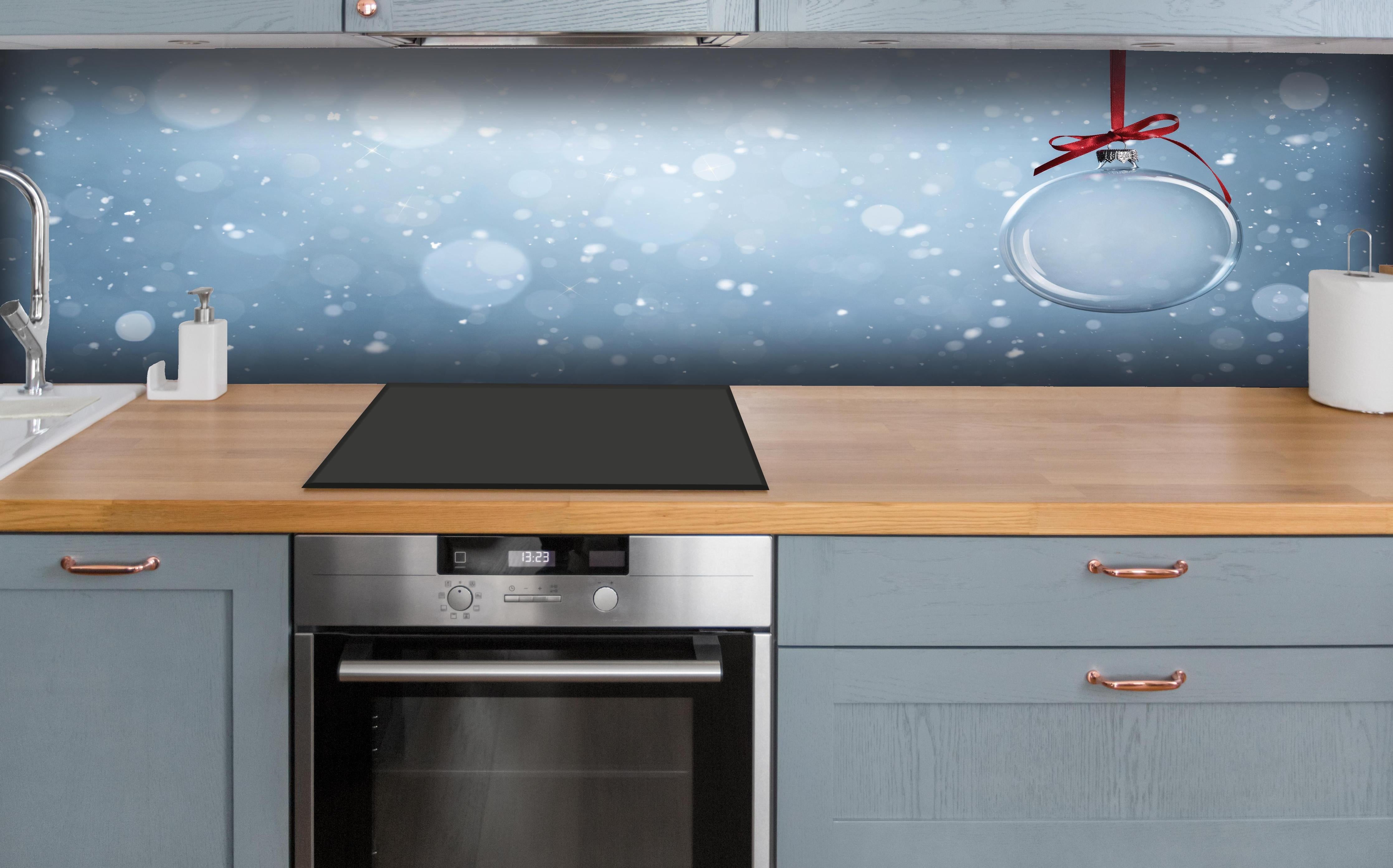 Küche - Leere Weihnachtskugel hinter weißen Hochglanz-Küchenregalen und schwarzem Wasserhahn