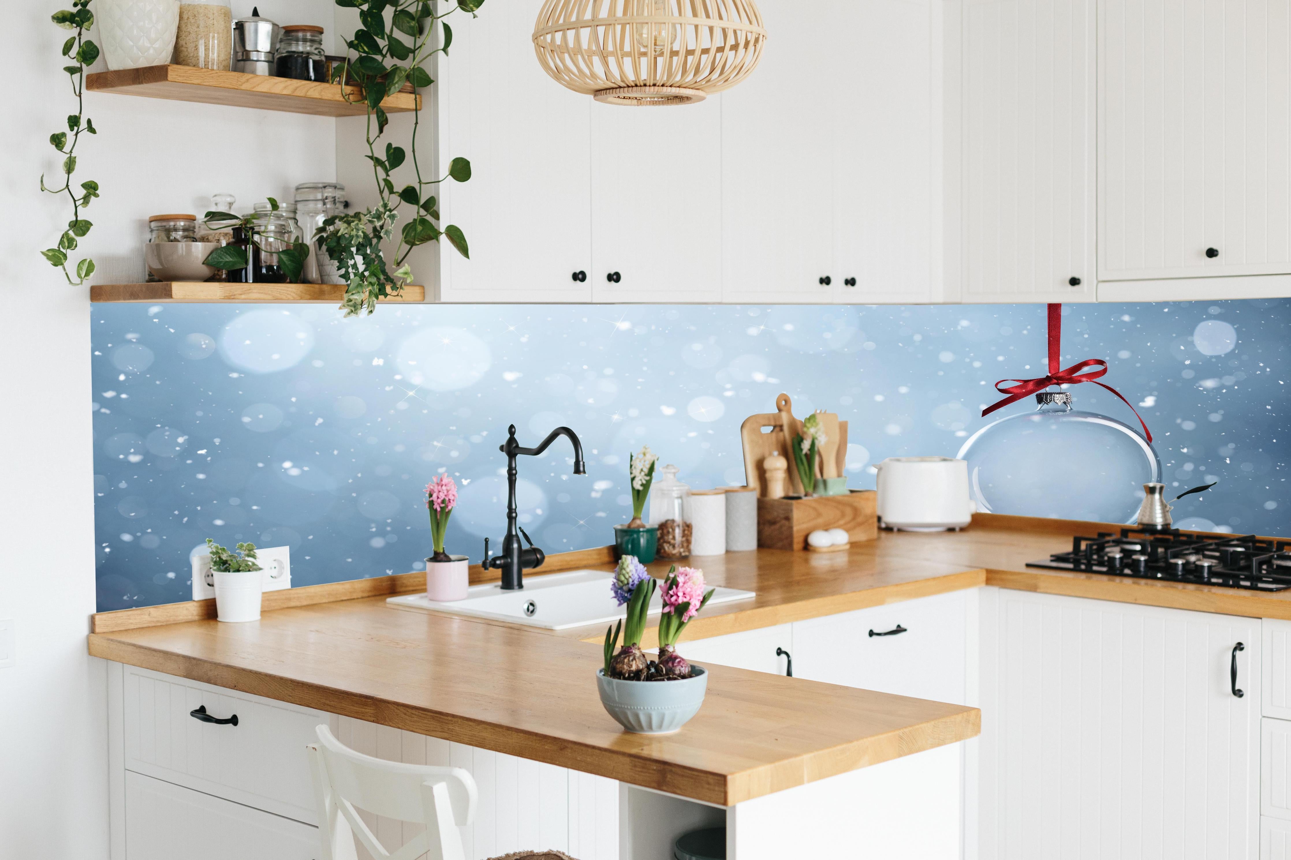 Küche - Leere Weihnachtskugel hinter weißen Hochglanz-Küchenregalen und schwarzem Wasserhahn