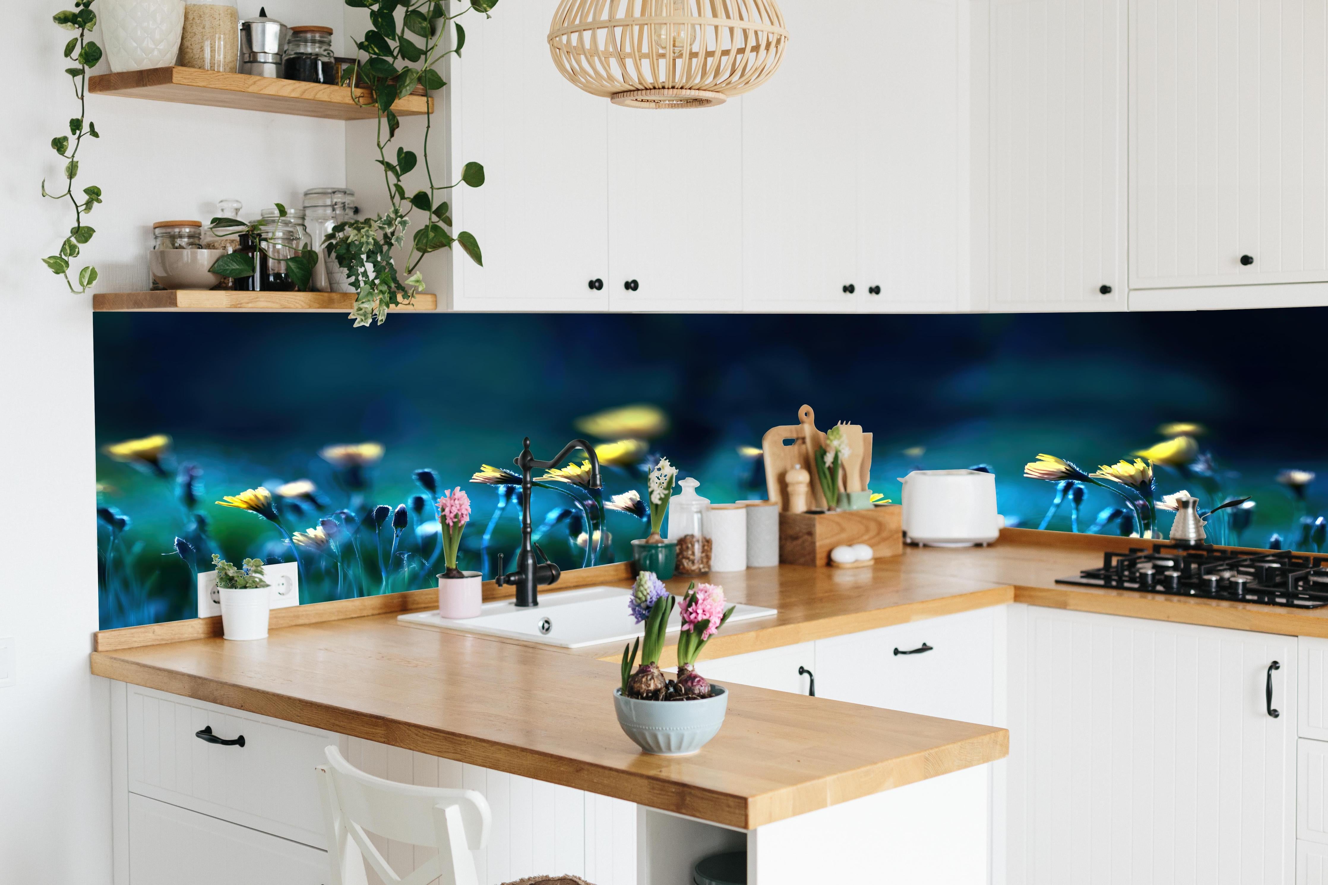 Küche - Leuchtende Blumen auf dunkelblauer Wiese hinter weißen Hochglanz-Küchenregalen und schwarzem Wasserhahn