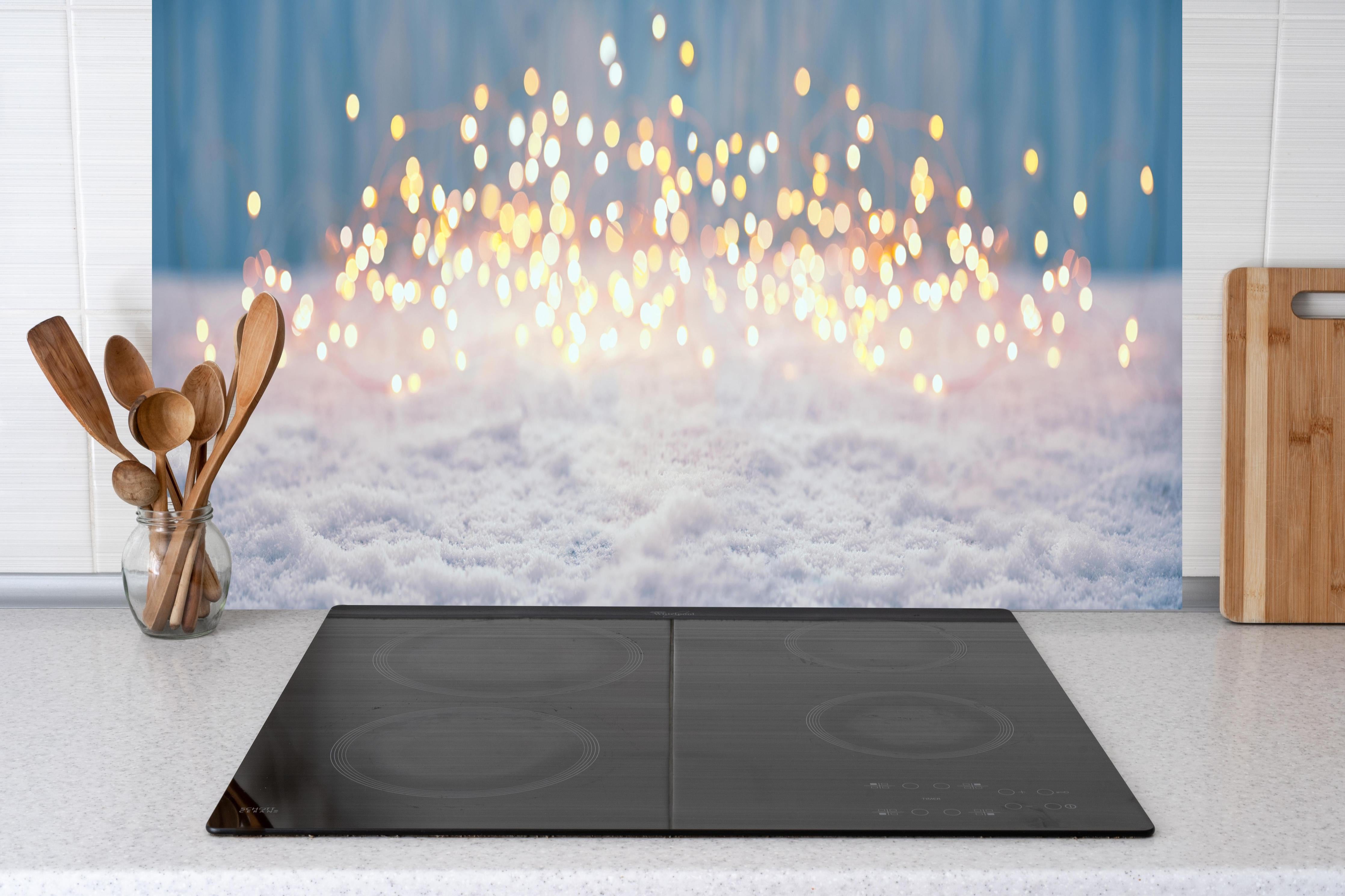 Küche - Magische Winterlandschaft mit goldenem Bokeh hinter weißen Hochglanz-Küchenregalen und schwarzem Wasserhahn