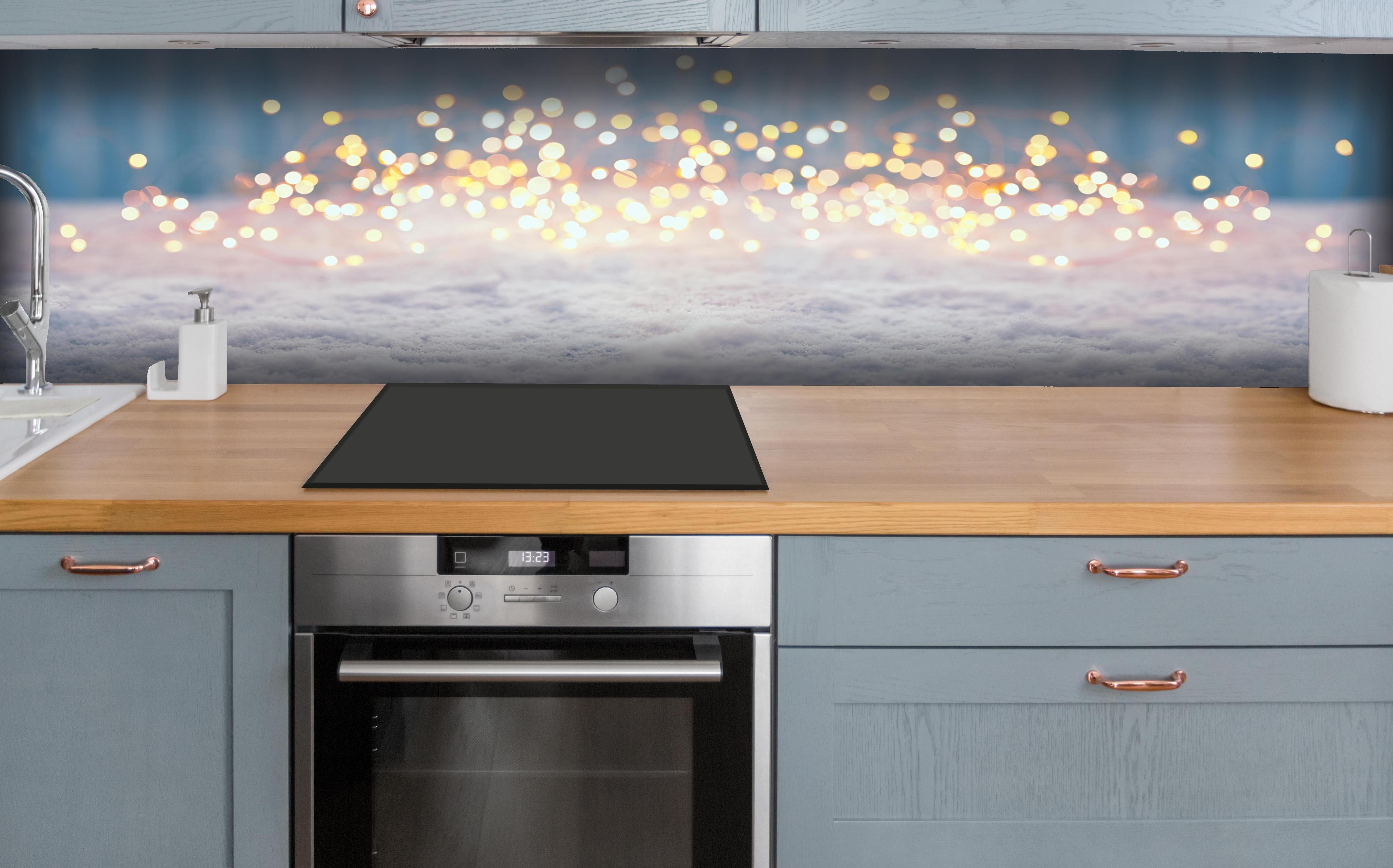 Küche - Magische Winterlandschaft mit goldenem Bokeh hinter weißen Hochglanz-Küchenregalen und schwarzem Wasserhahn