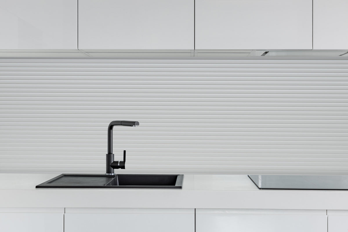 Küche - Moderne Weiß-Graue Lamellen Wandverkleidung hinter weißen Hochglanz-Küchenregalen und schwarzem Wasserhahn