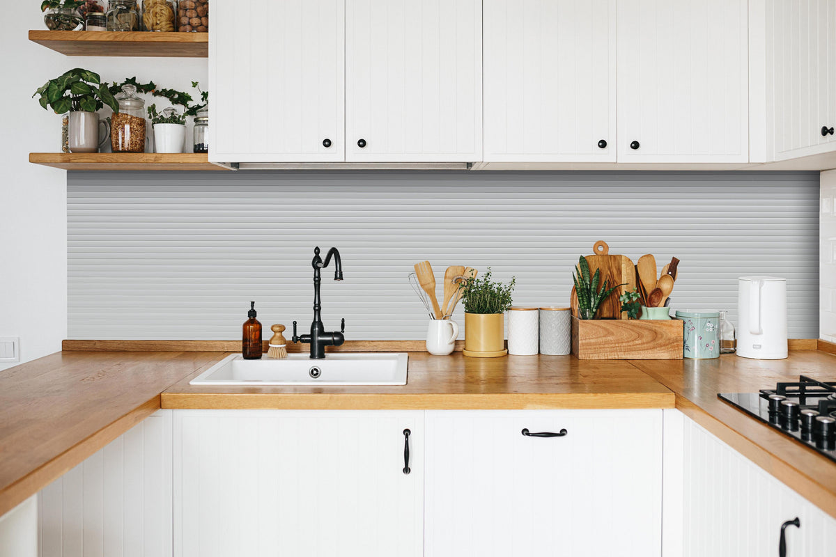 Küche - Moderne Weiß-Graue Lamellen Wandverkleidung hinter weißen Hochglanz-Küchenregalen und schwarzem Wasserhahn