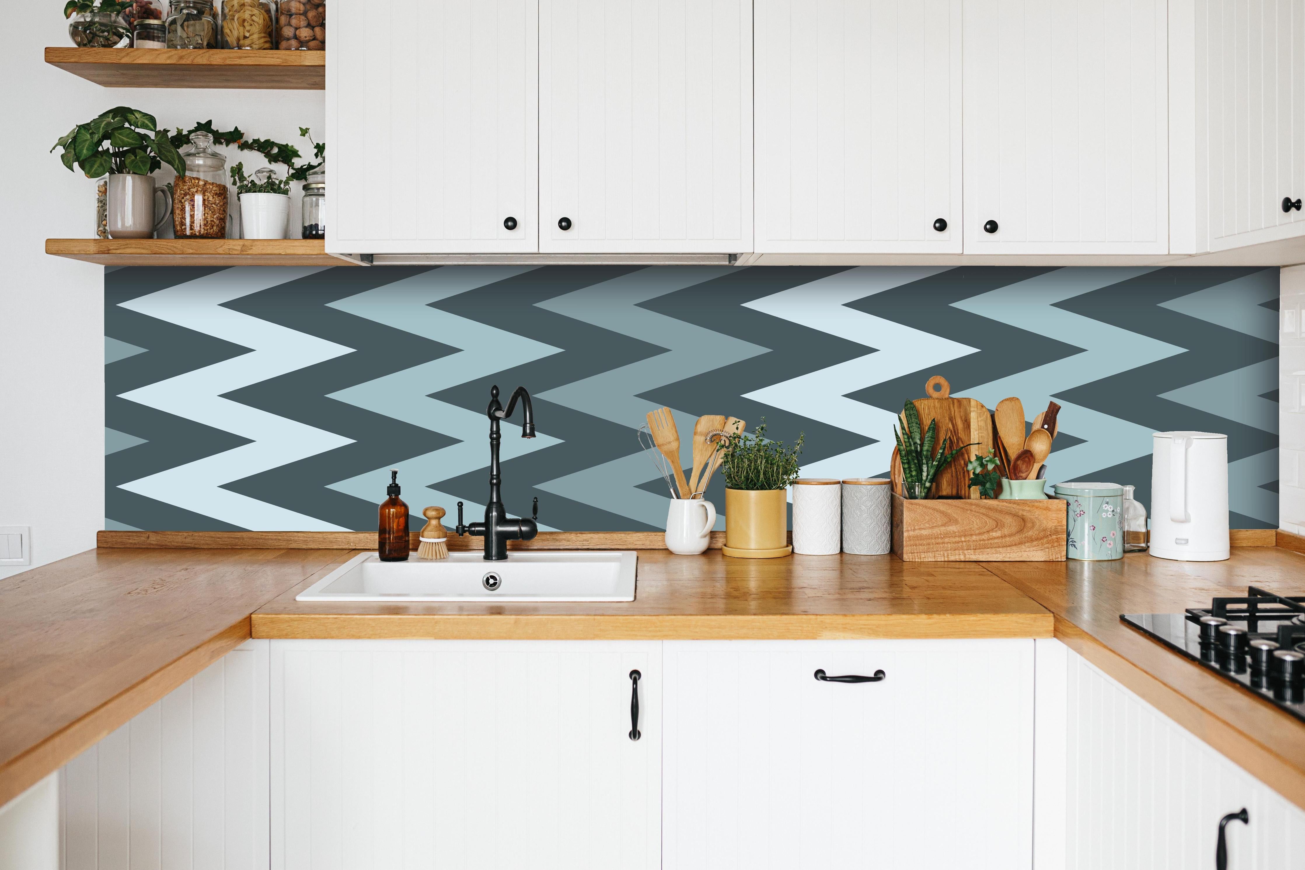 Küche - Modernes Chevron Design in Grau-Weiß hinter weißen Hochglanz-Küchenregalen und schwarzem Wasserhahn