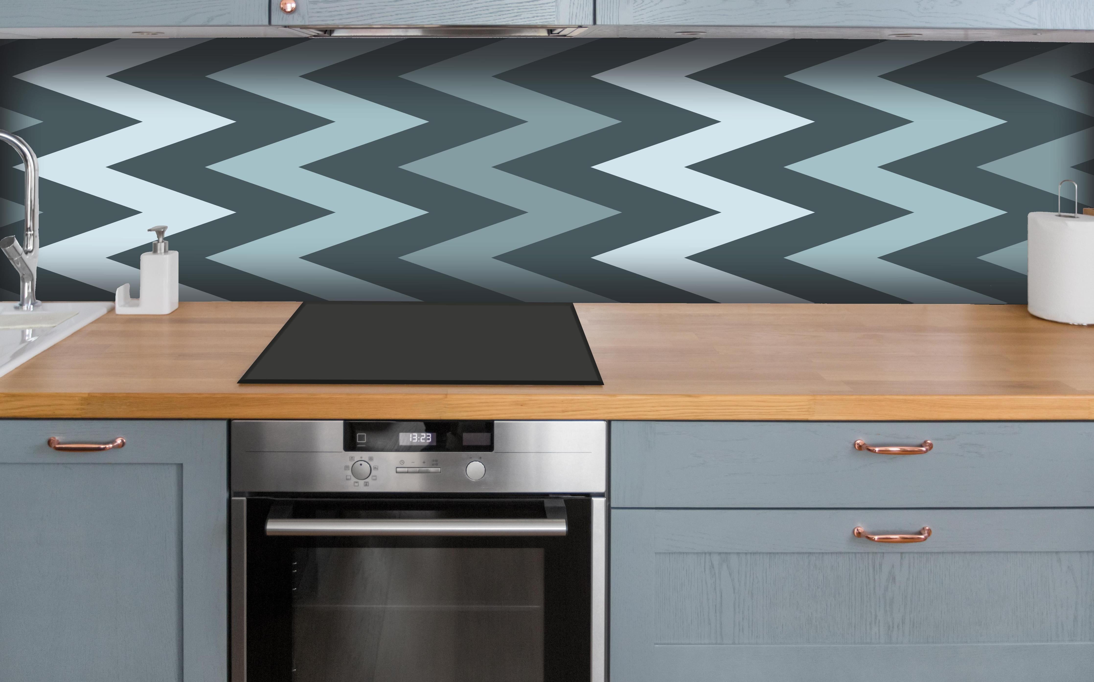 Küche - Modernes Chevron Design in Grau-Weiß hinter weißen Hochglanz-Küchenregalen und schwarzem Wasserhahn