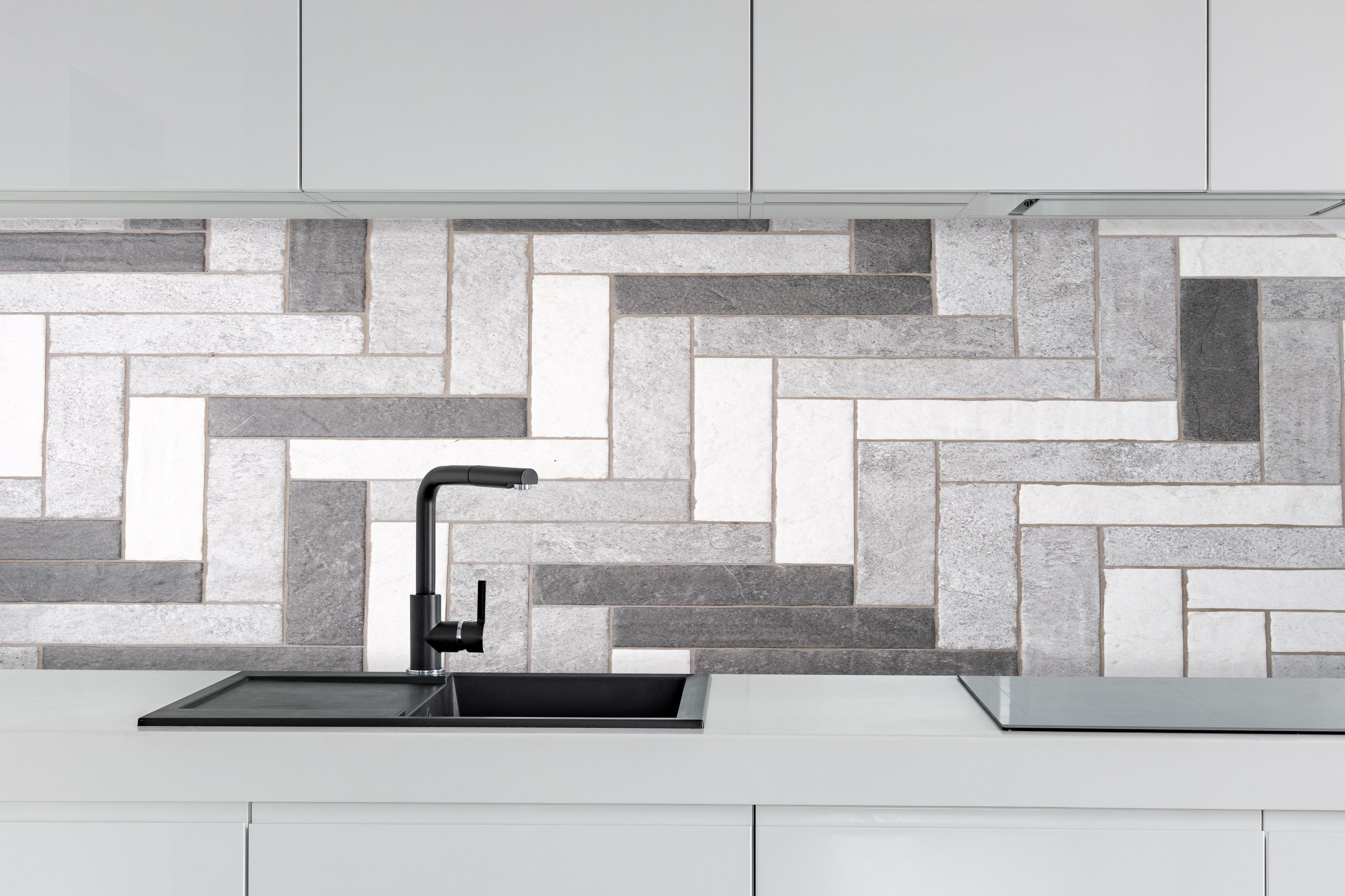 Küche - Mosaikbodenfliesen in Rechtecken hinter weißen Hochglanz-Küchenregalen und schwarzem Wasserhahn