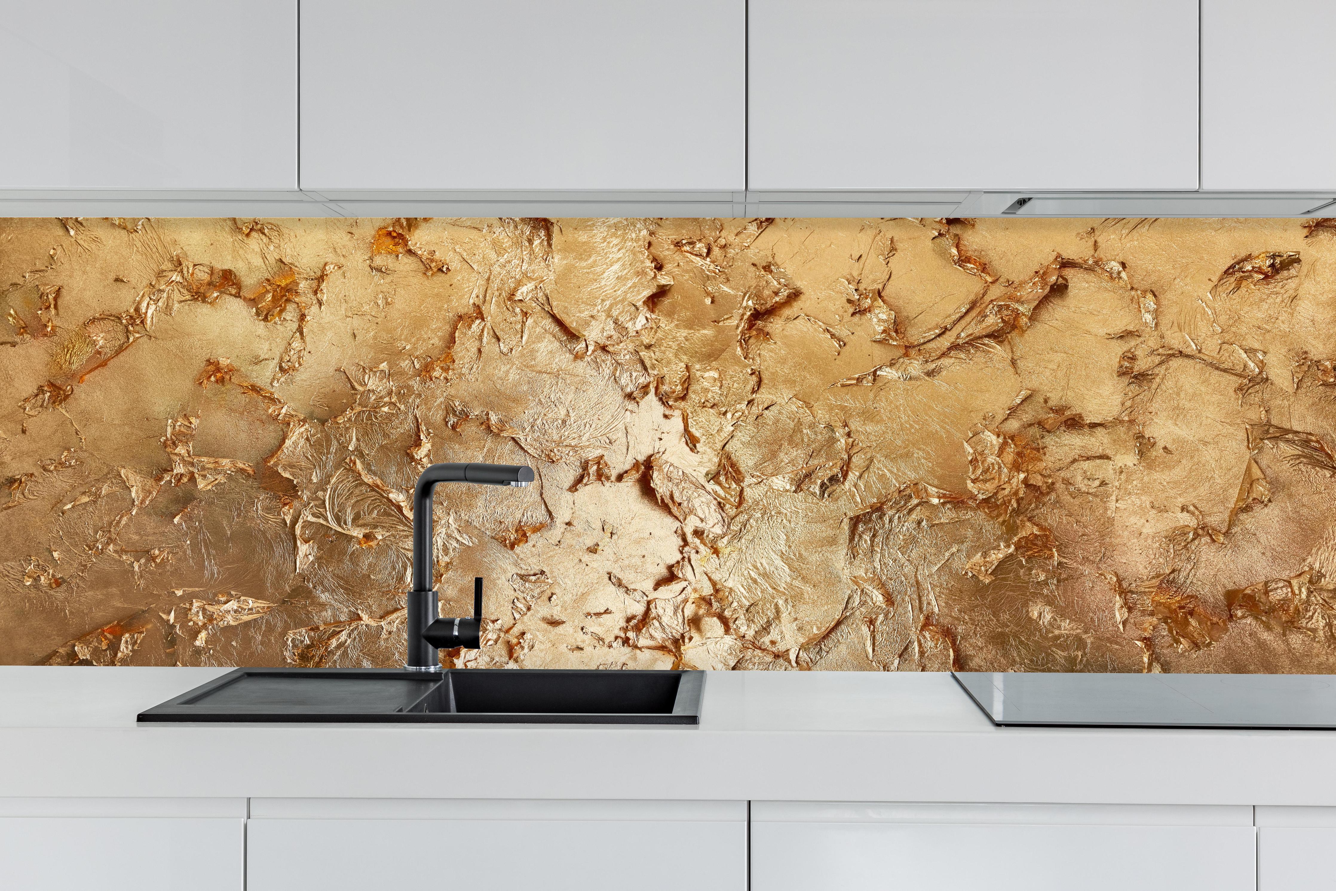 Küche - Muster einer vergoldeten Wand hinter weißen Hochglanz-Küchenregalen und schwarzem Wasserhahn