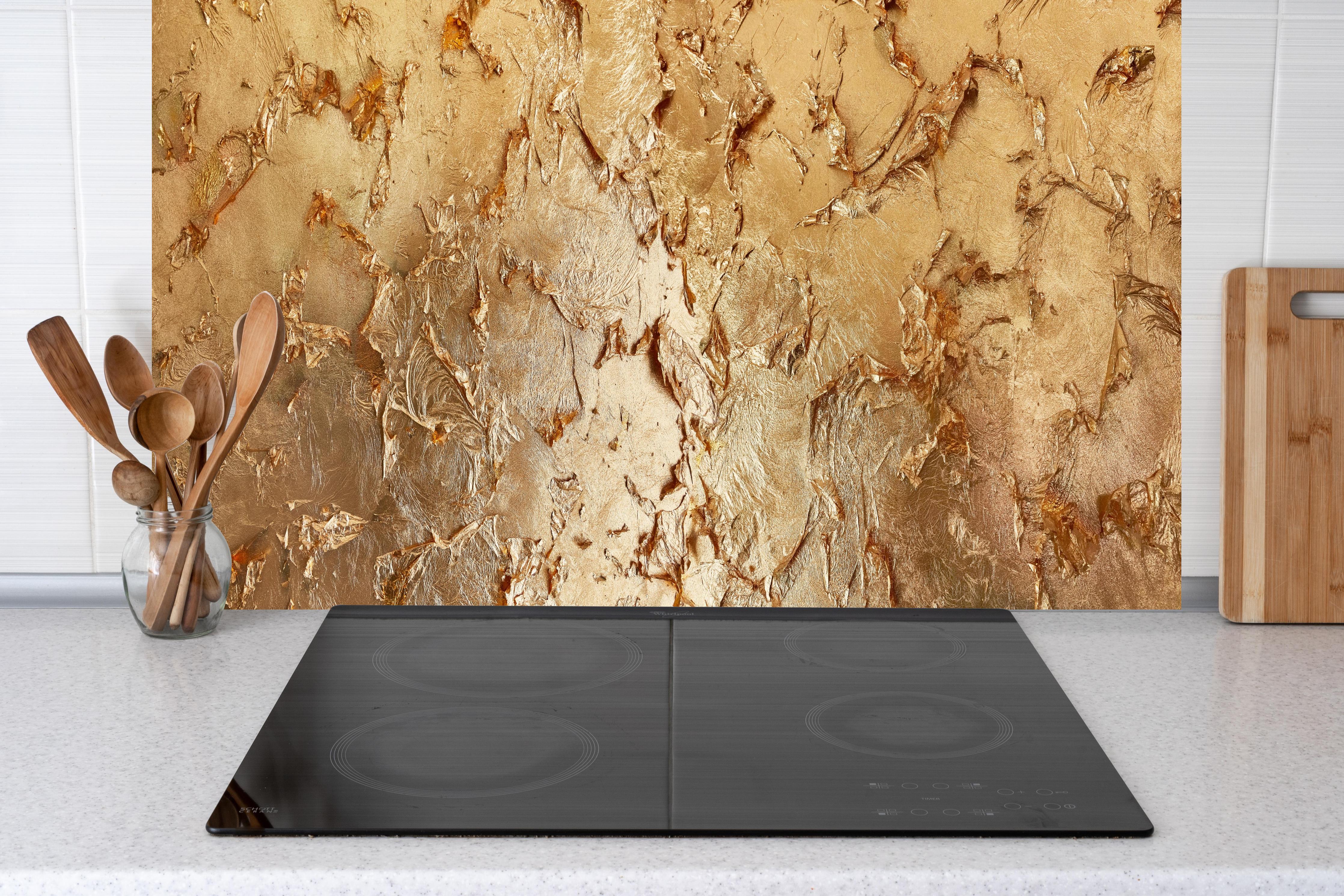 Küche - Muster einer vergoldeten Wand hinter weißen Hochglanz-Küchenregalen und schwarzem Wasserhahn