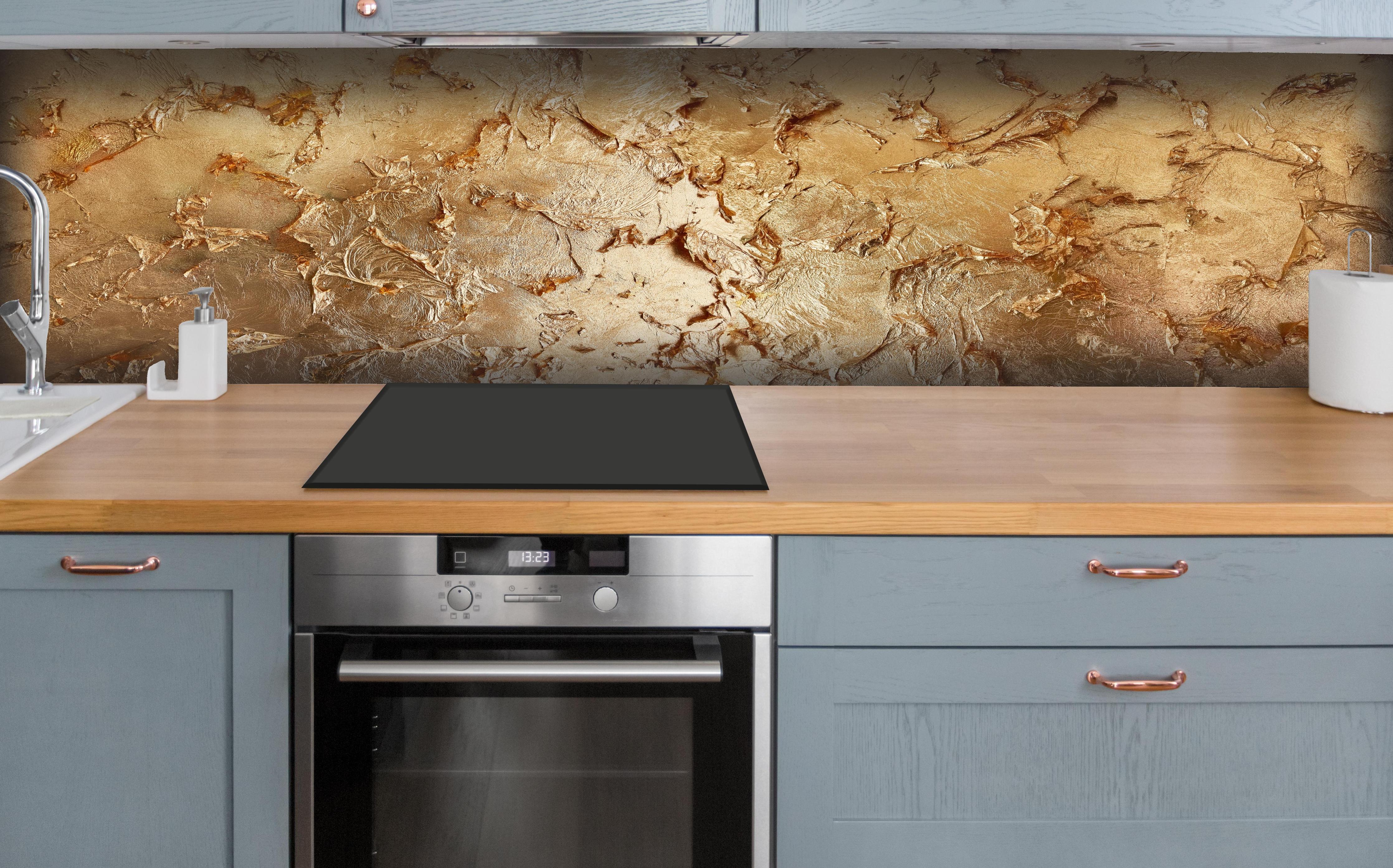 Küche - Muster einer vergoldeten Wand hinter weißen Hochglanz-Küchenregalen und schwarzem Wasserhahn