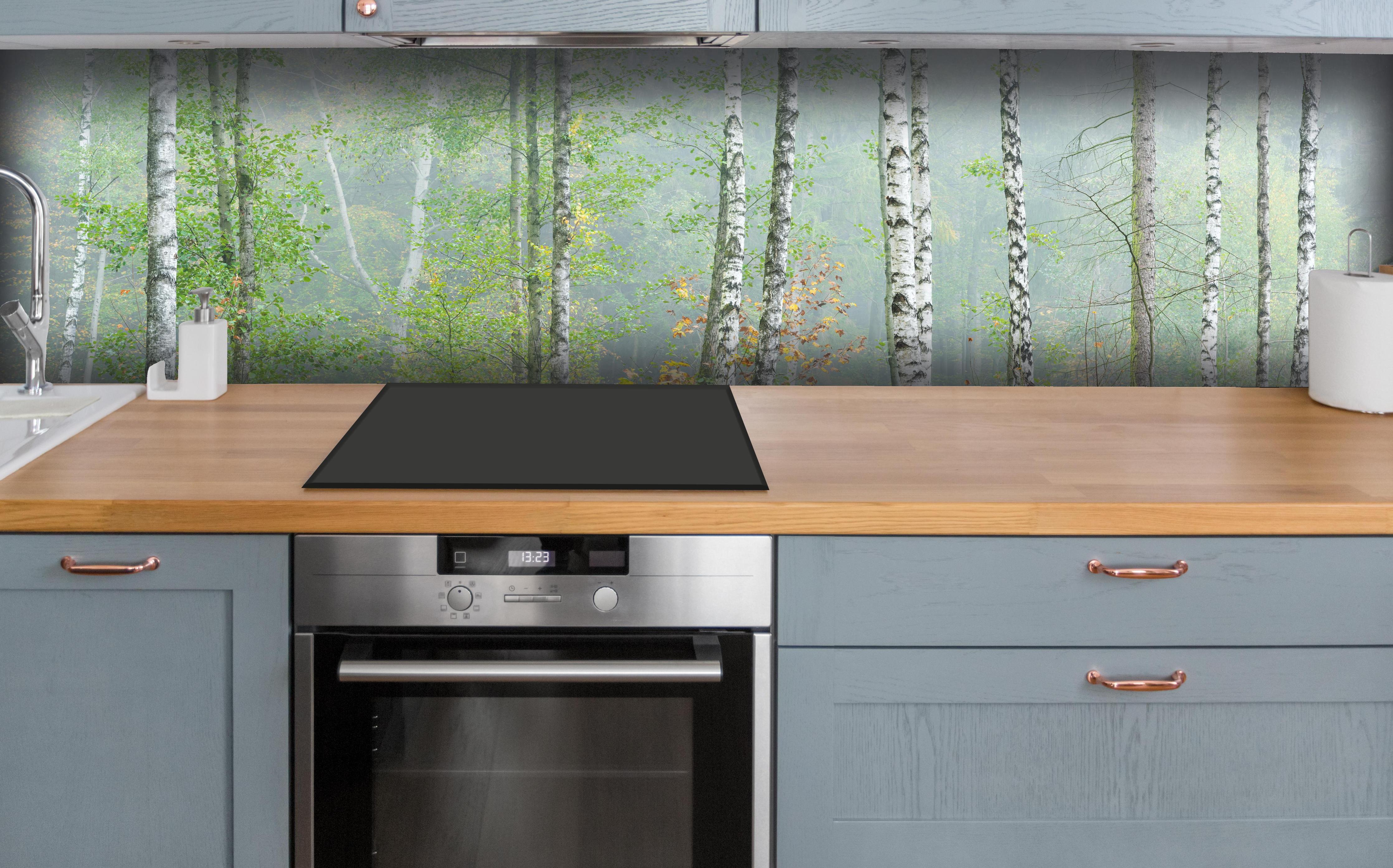 Küche - Nebeliger Birkenwald hinter weißen Hochglanz-Küchenregalen und schwarzem Wasserhahn