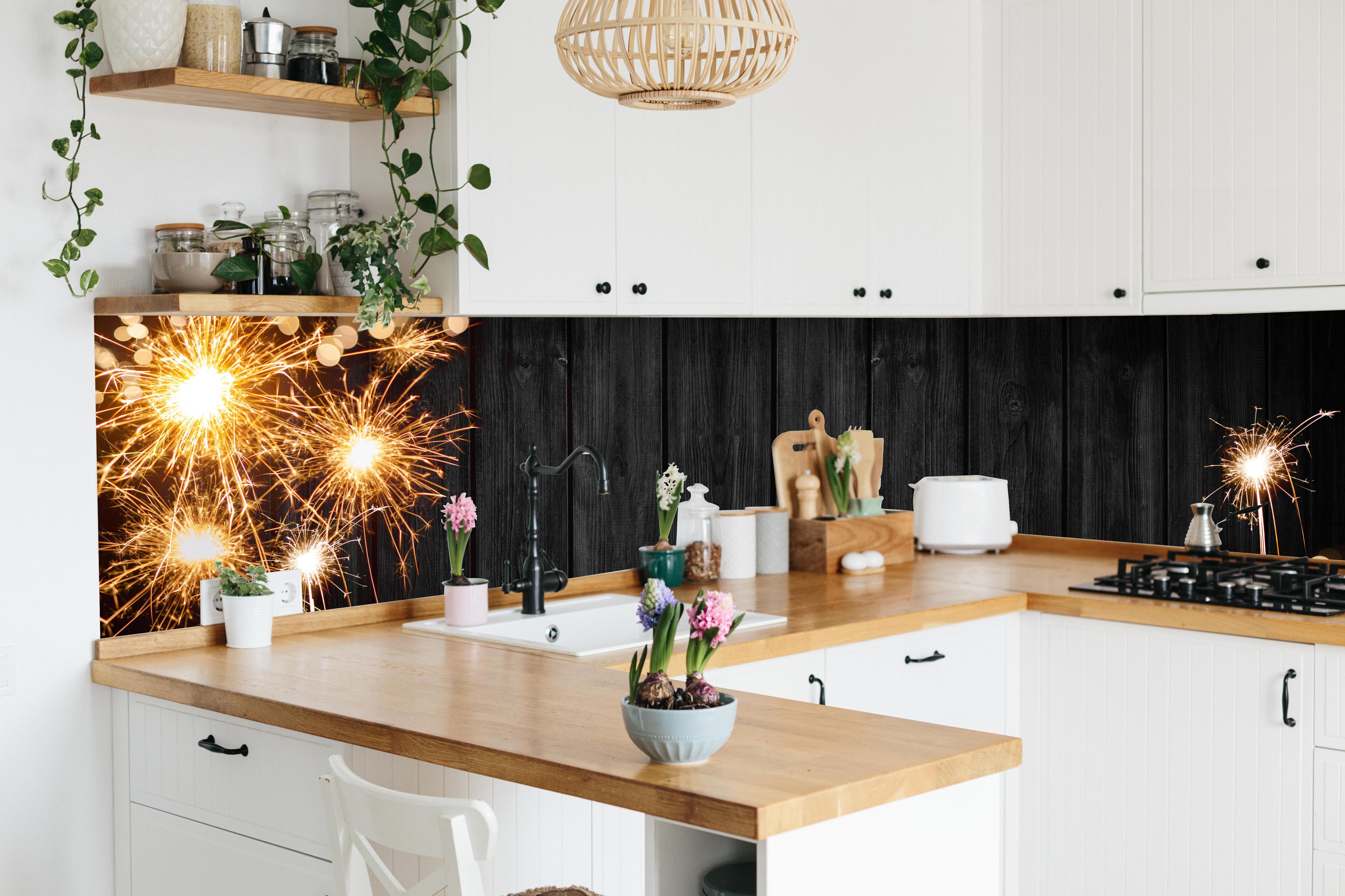 Küche - Neujahr Feuerwerk Funken auf Schwarz hinter weißen Hochglanz-Küchenregalen und schwarzem Wasserhahn