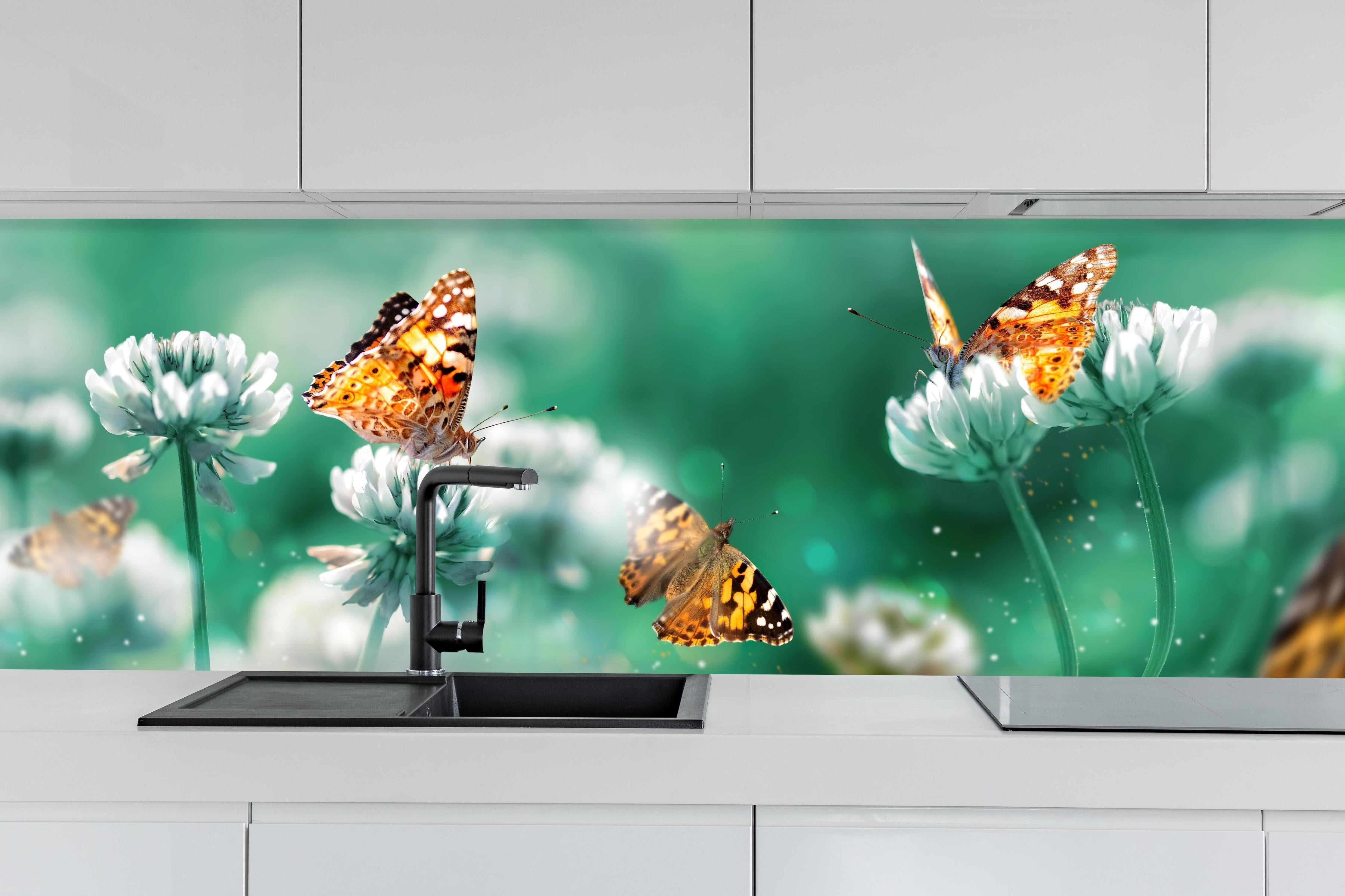 Küche - Orange Schmetterlinge Sommergarten hinter weißen Hochglanz-Küchenregalen und schwarzem Wasserhahn