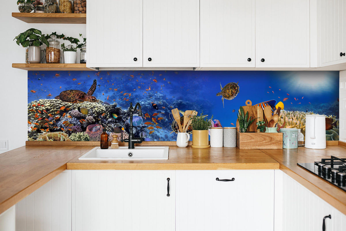 Küche - Panorama: Korallenriff mit Meerestieren hinter weißen Hochglanz-Küchenregalen und schwarzem Wasserhahn