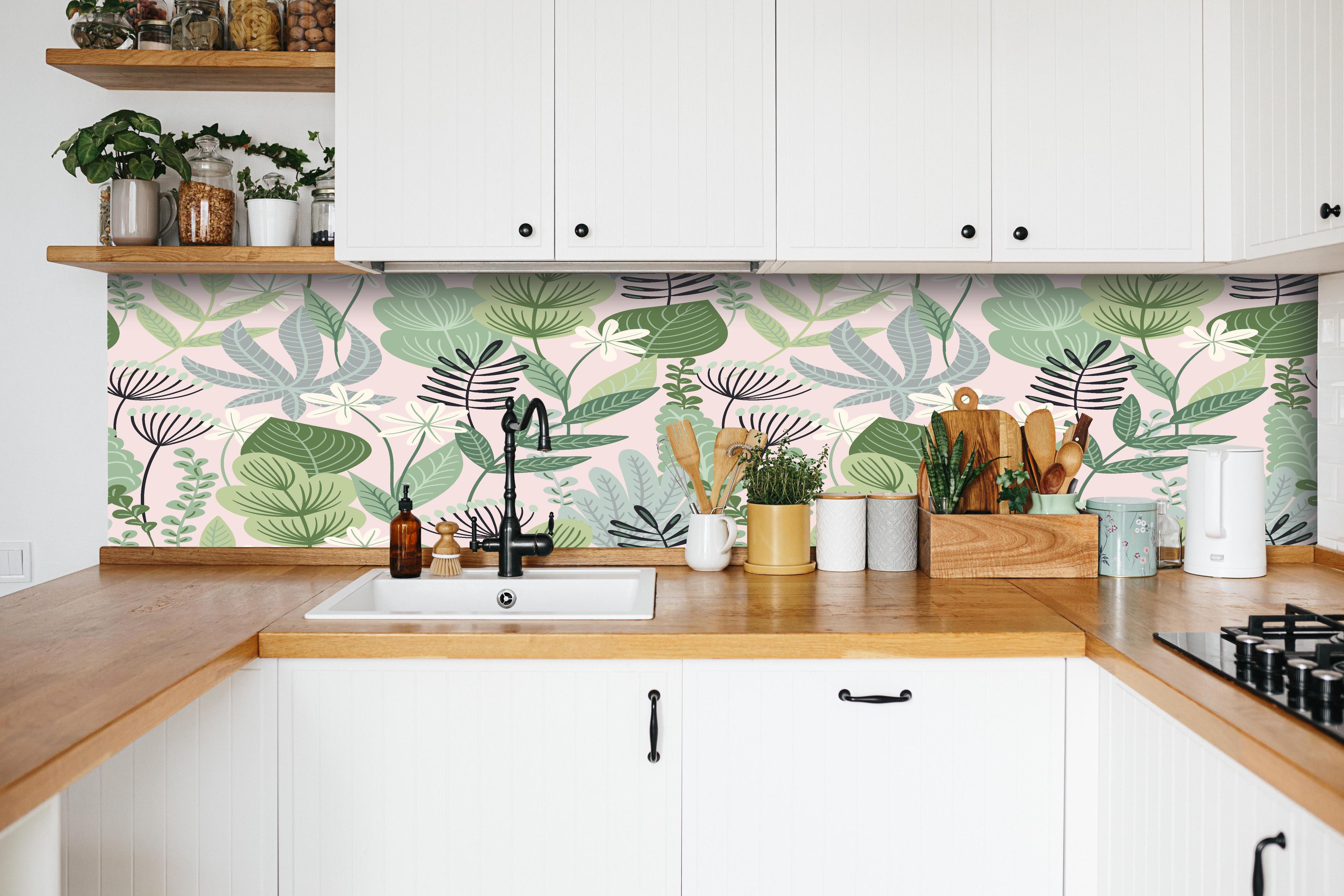 Küche - Pastellfarbenes Blumenmuster in Grün und Rosa hinter weißen Hochglanz-Küchenregalen und schwarzem Wasserhahn