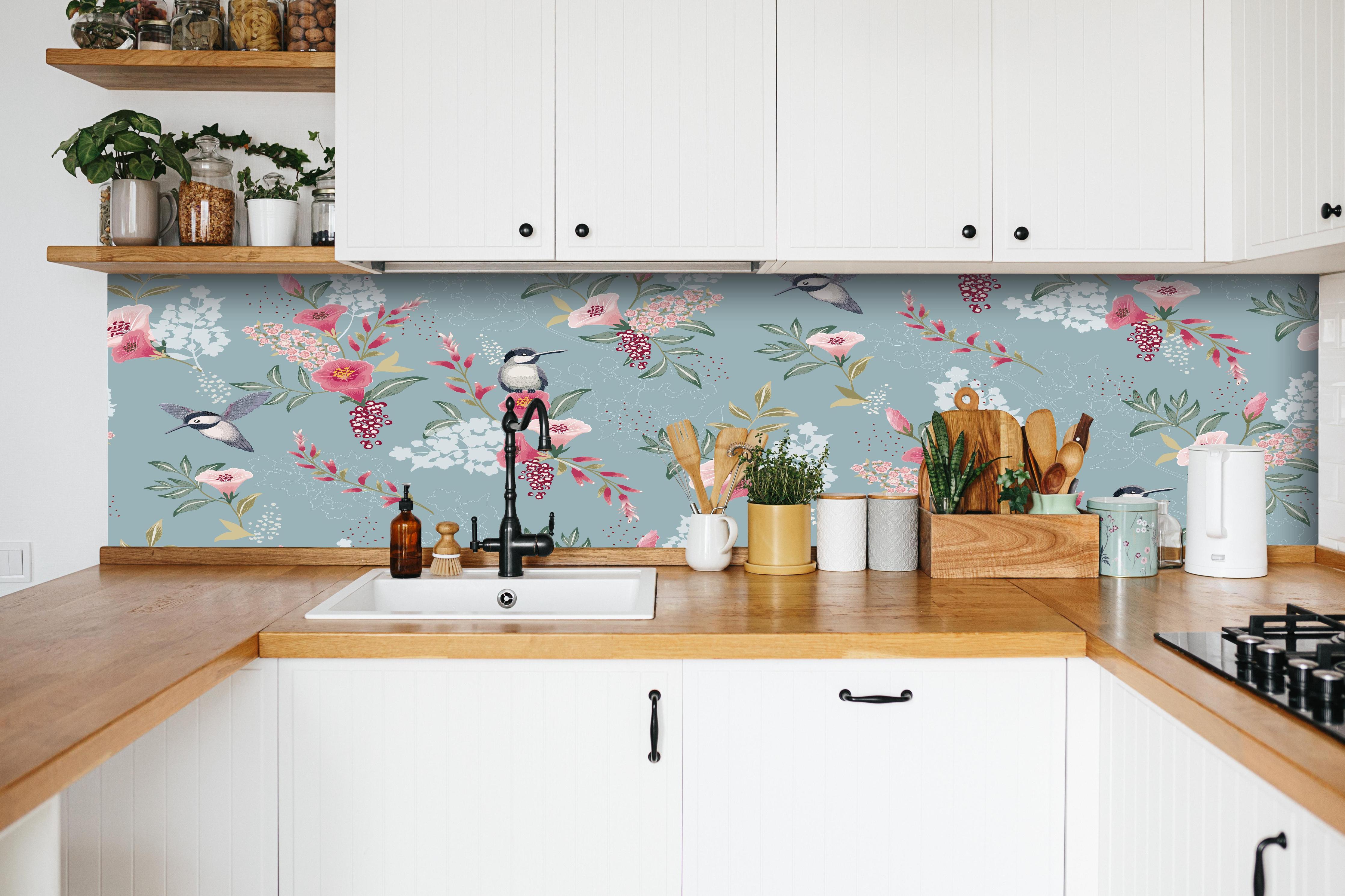 Küche - Pastellfarbenes Blumenmuster mit Kohlmeisen hinter weißen Hochglanz-Küchenregalen und schwarzem Wasserhahn
