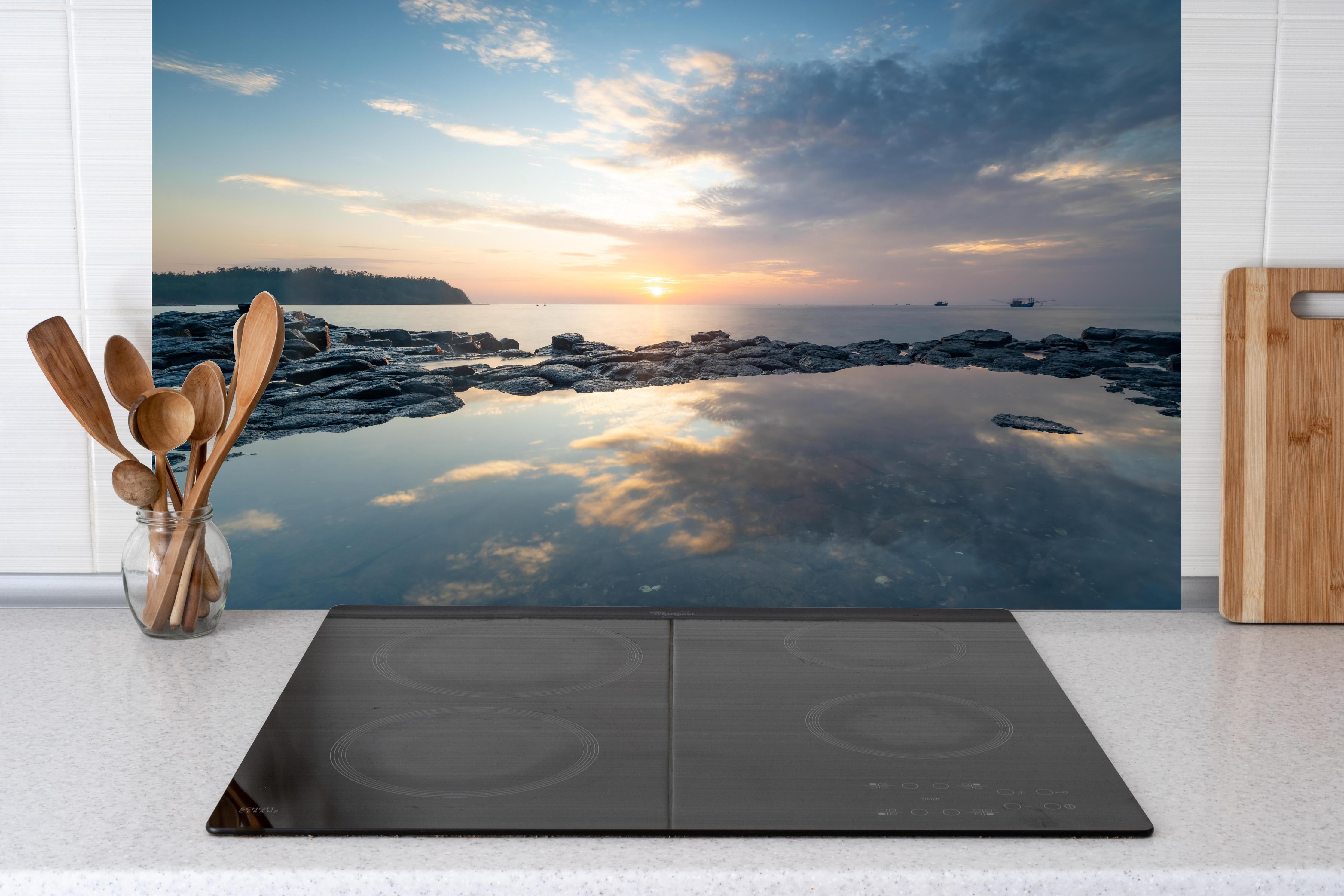 Küche - Pittoresker Sonnenuntergang über dem ruhigen Meer mit reflektierendem Wasser hinter weißen Hochglanz-Küchenregalen und schwarzem Wasserhahn