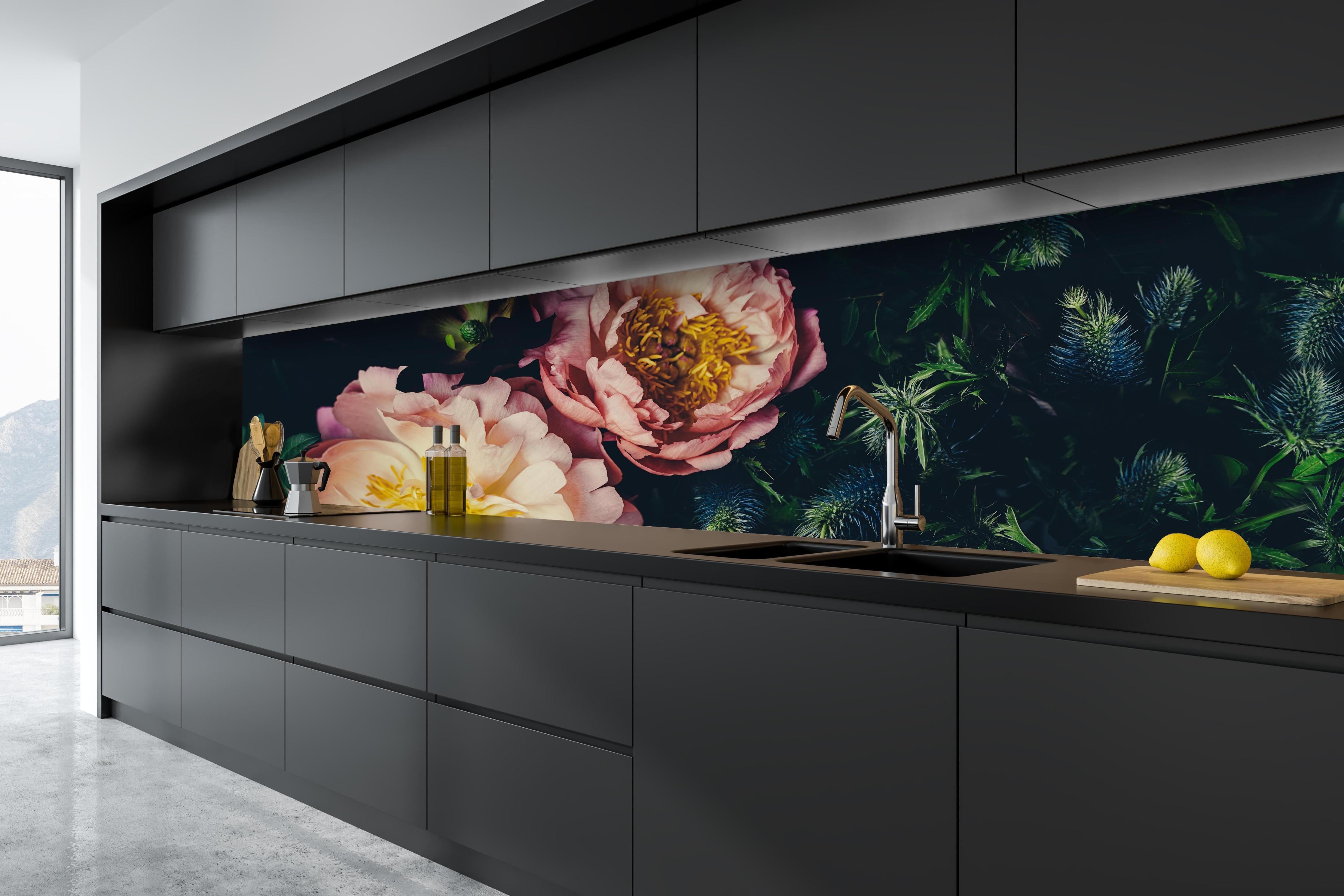 Küche - Rosa Blüten auf einer Wiese hinter weißen Hochglanz-Küchenregalen und schwarzem Wasserhahn