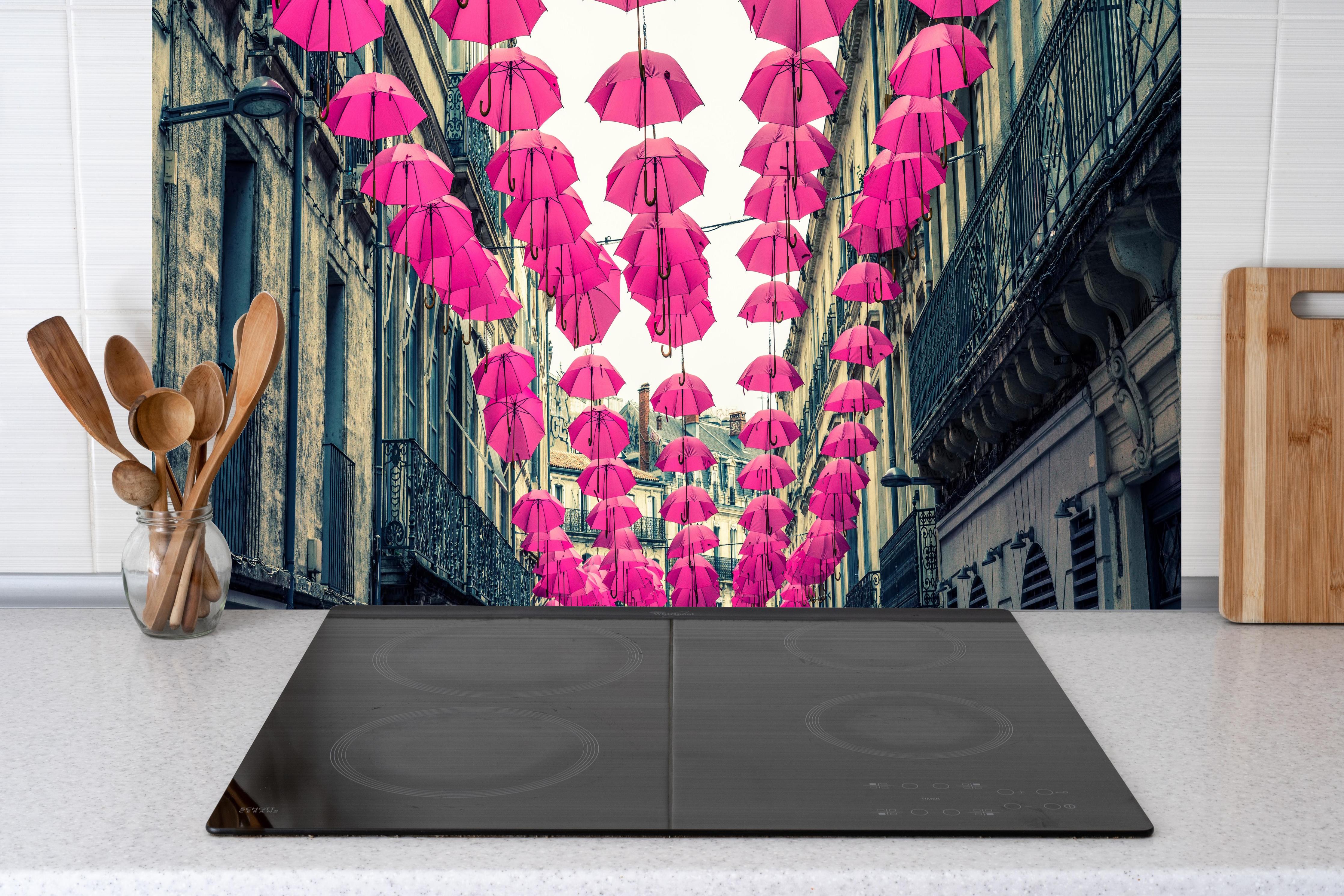 Küche - Rosafarbene Regenschirme als Straßenkunst hinter weißen Hochglanz-Küchenregalen und schwarzem Wasserhahn