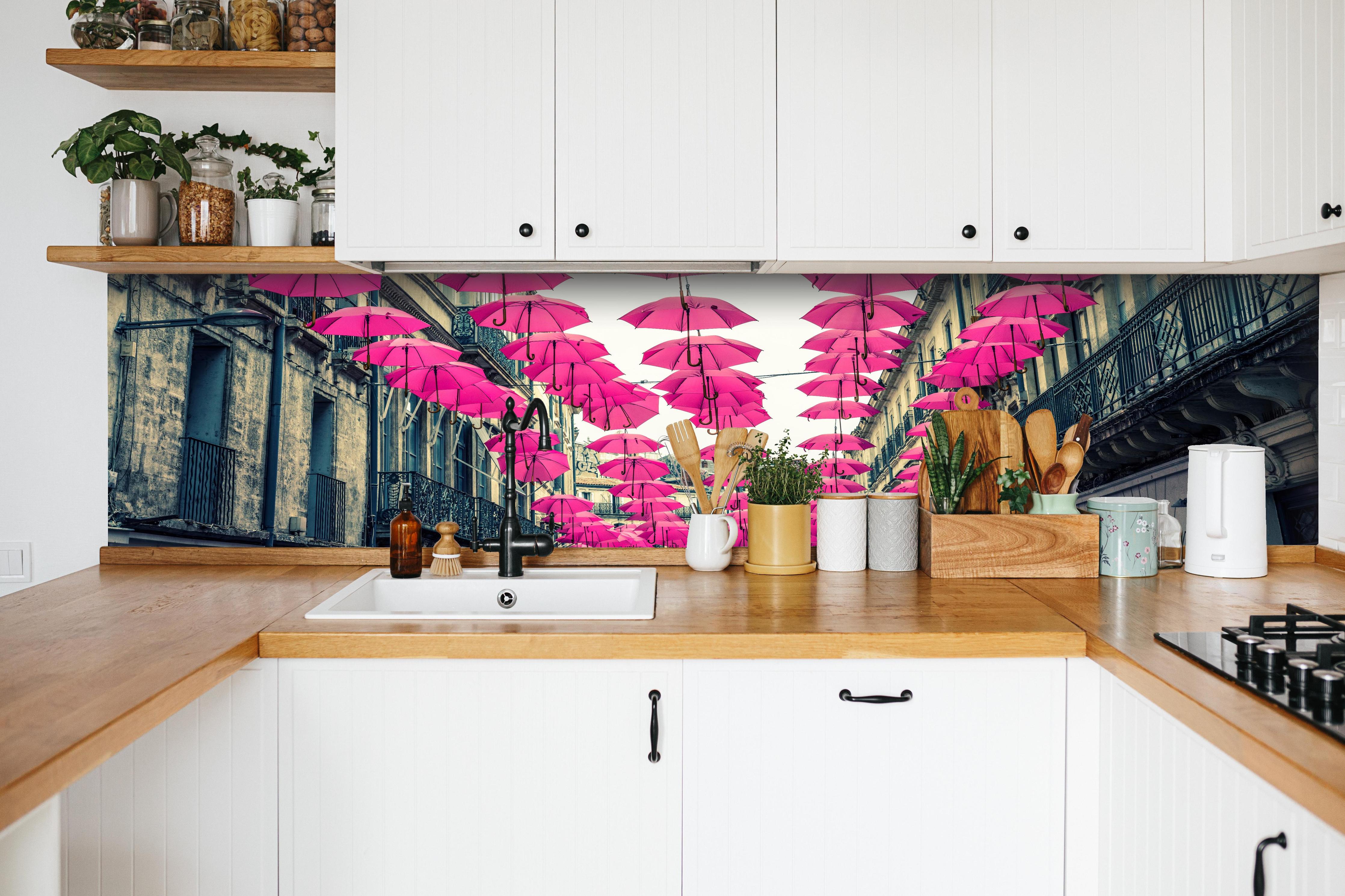 Küche - Rosafarbene Regenschirme als Straßenkunst hinter weißen Hochglanz-Küchenregalen und schwarzem Wasserhahn