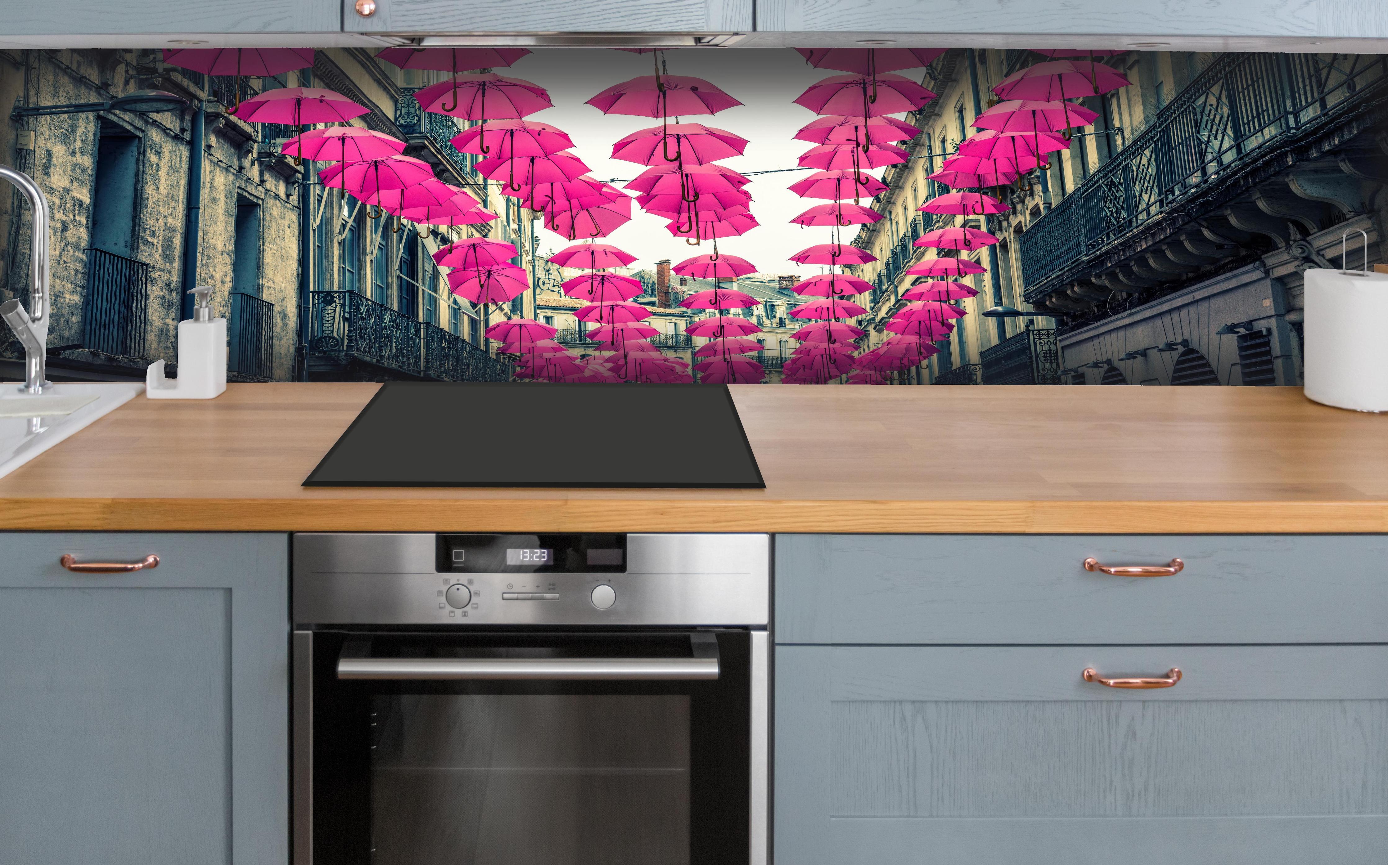 Küche - Rosafarbene Regenschirme als Straßenkunst hinter weißen Hochglanz-Küchenregalen und schwarzem Wasserhahn