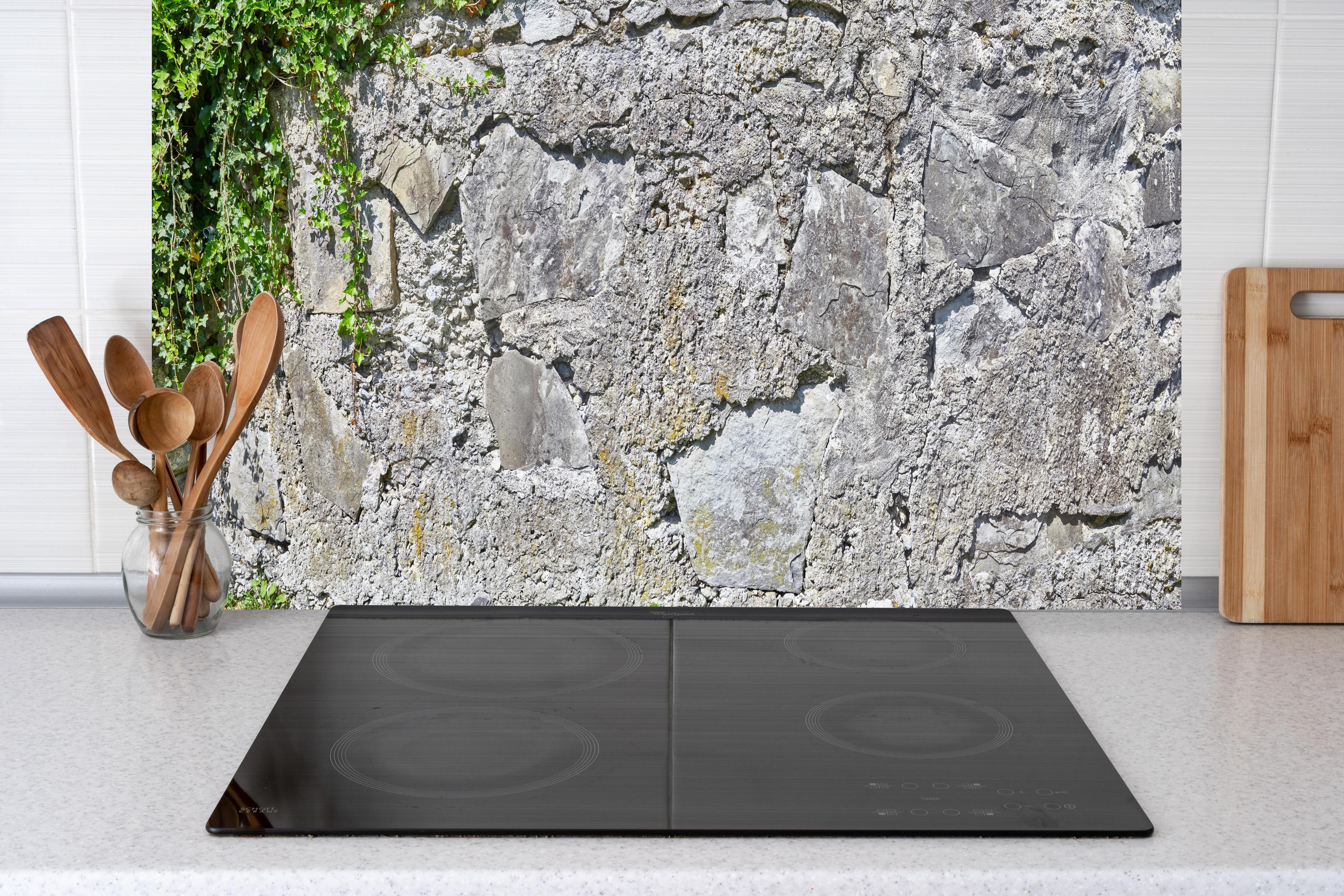 Küche - Rustikale Schiefermauer hinter weißen Hochglanz-Küchenregalen und schwarzem Wasserhahn