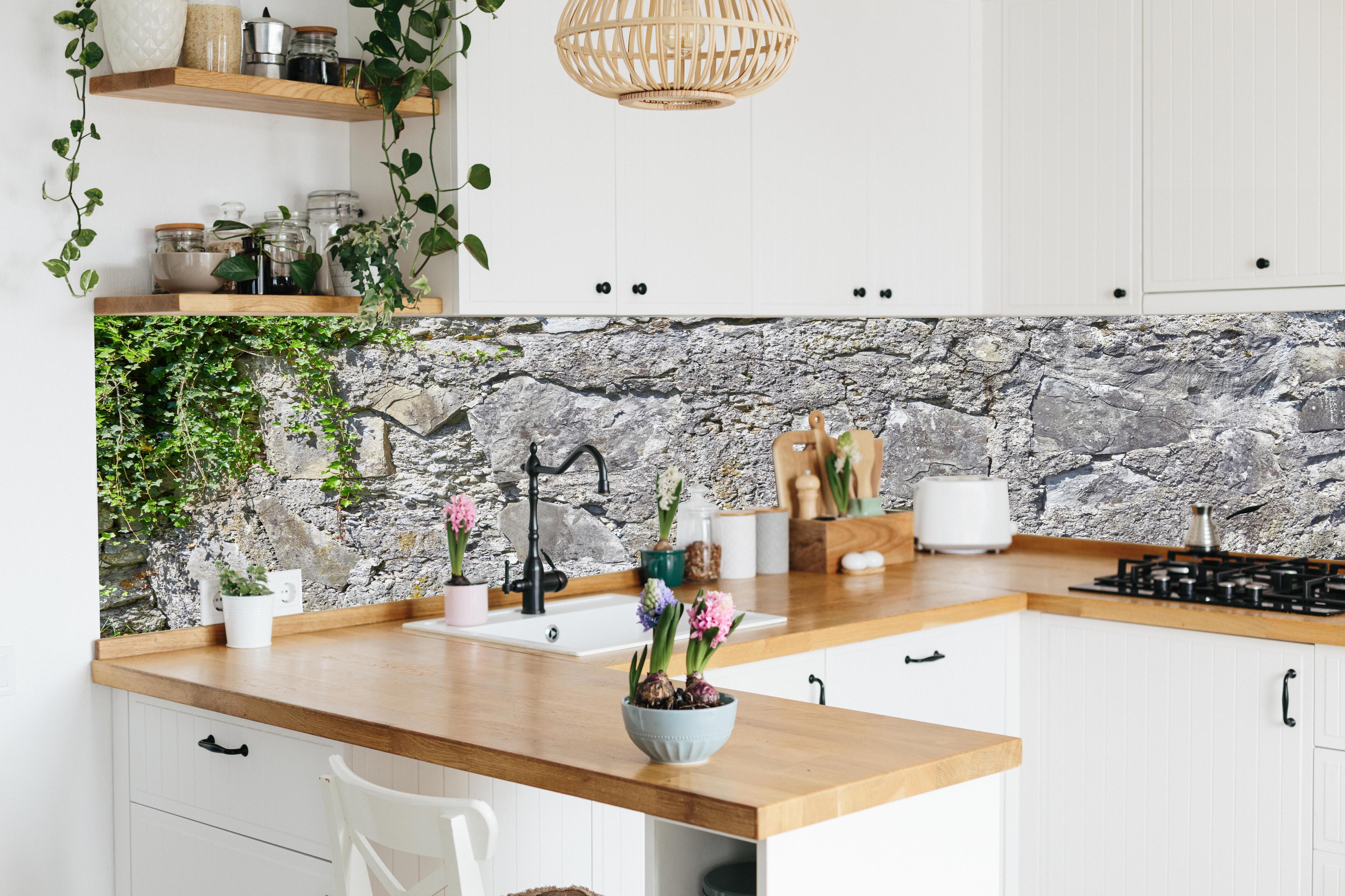 Küche - Rustikale Schiefermauer hinter weißen Hochglanz-Küchenregalen und schwarzem Wasserhahn