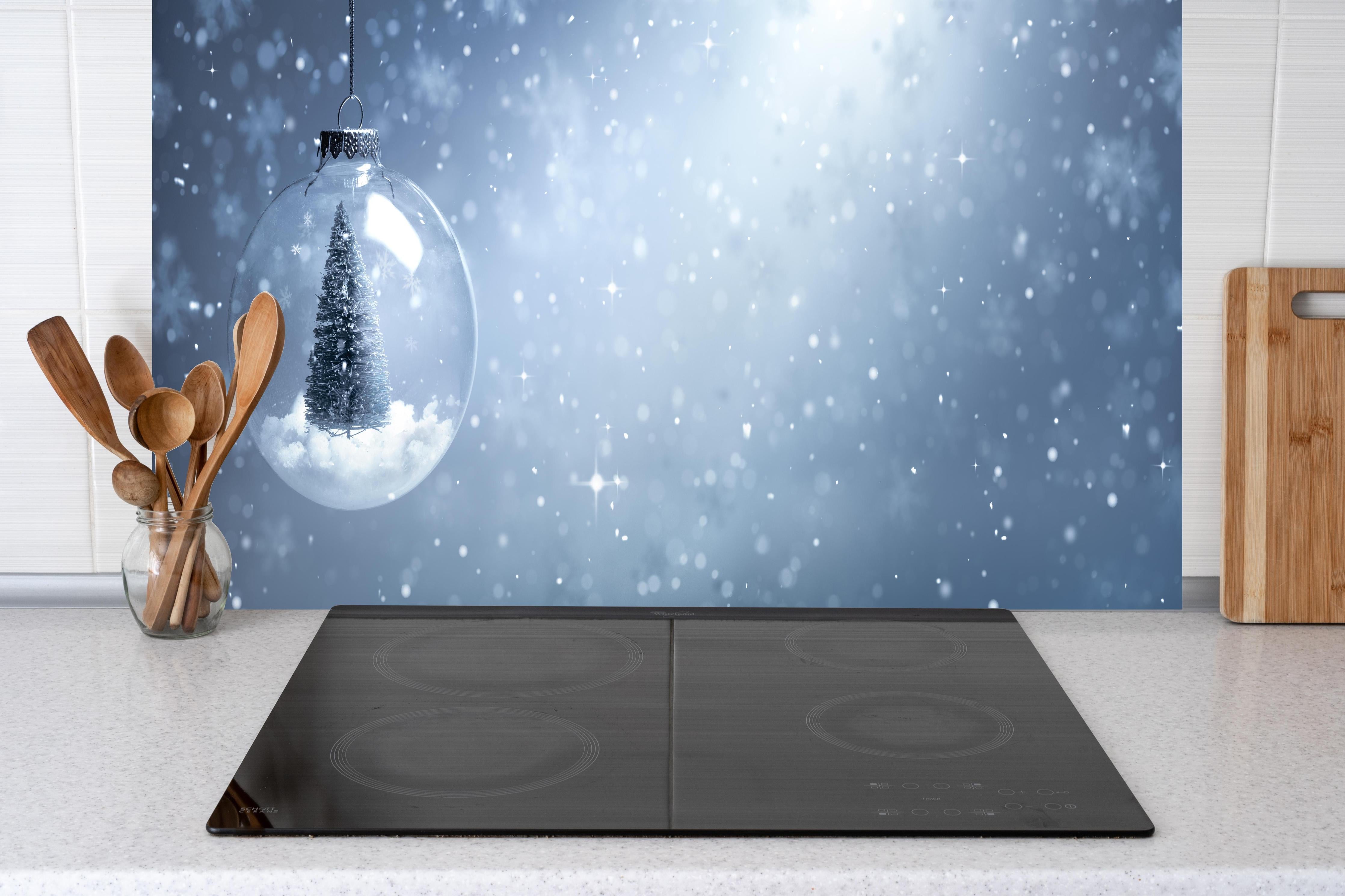 Küche - Schneekugel mit Weihnachtsbaum hinter weißen Hochglanz-Küchenregalen und schwarzem Wasserhahn