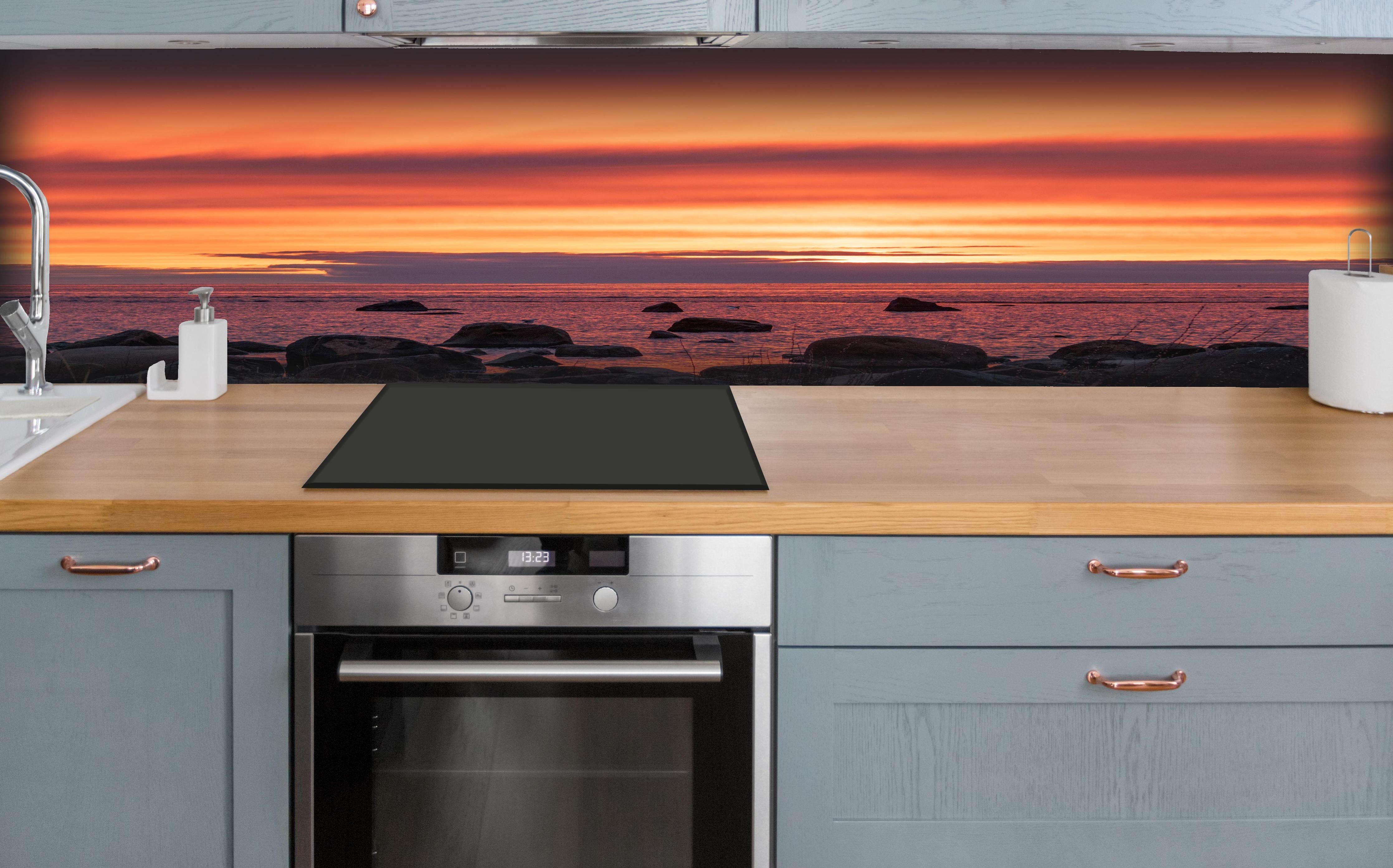 Küche - Schöner Sonnenuntergang am Meer hinter weißen Hochglanz-Küchenregalen und schwarzem Wasserhahn