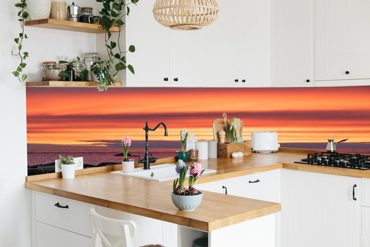 Küche - Schöner Sonnenuntergang am Meer hinter weißen Hochglanz-Küchenregalen und schwarzem Wasserhahn