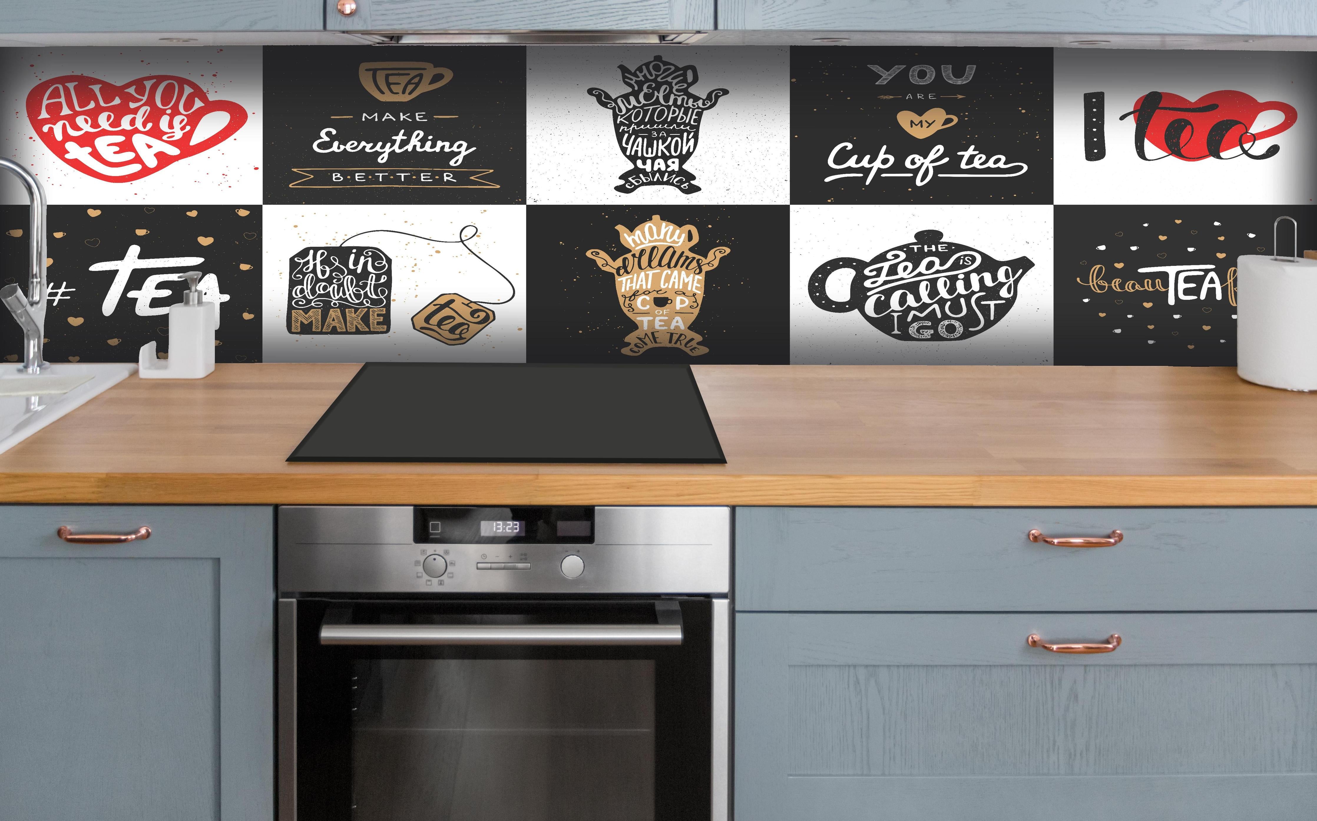 Küche - Schriftzug Sammlung für Tee Enthusiasten hinter weißen Hochglanz-Küchenregalen und schwarzem Wasserhahn