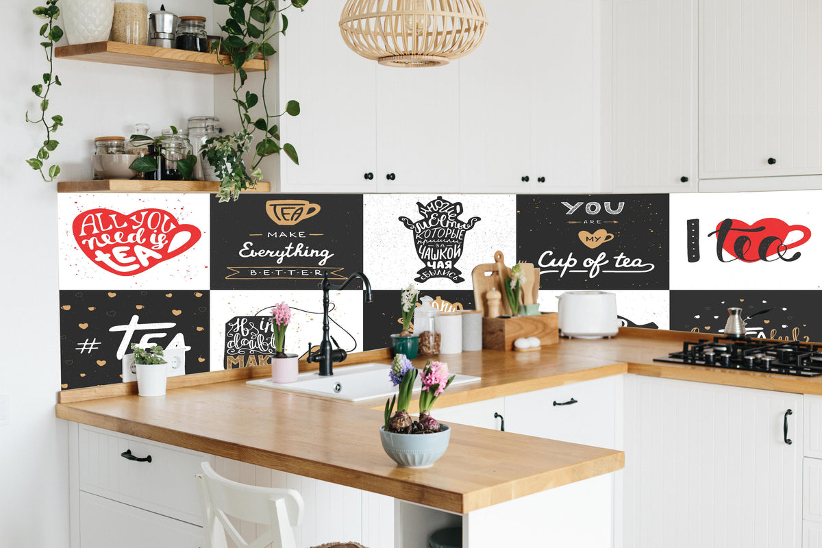 Küche - Schriftzug Sammlung für Tee Enthusiasten hinter weißen Hochglanz-Küchenregalen und schwarzem Wasserhahn