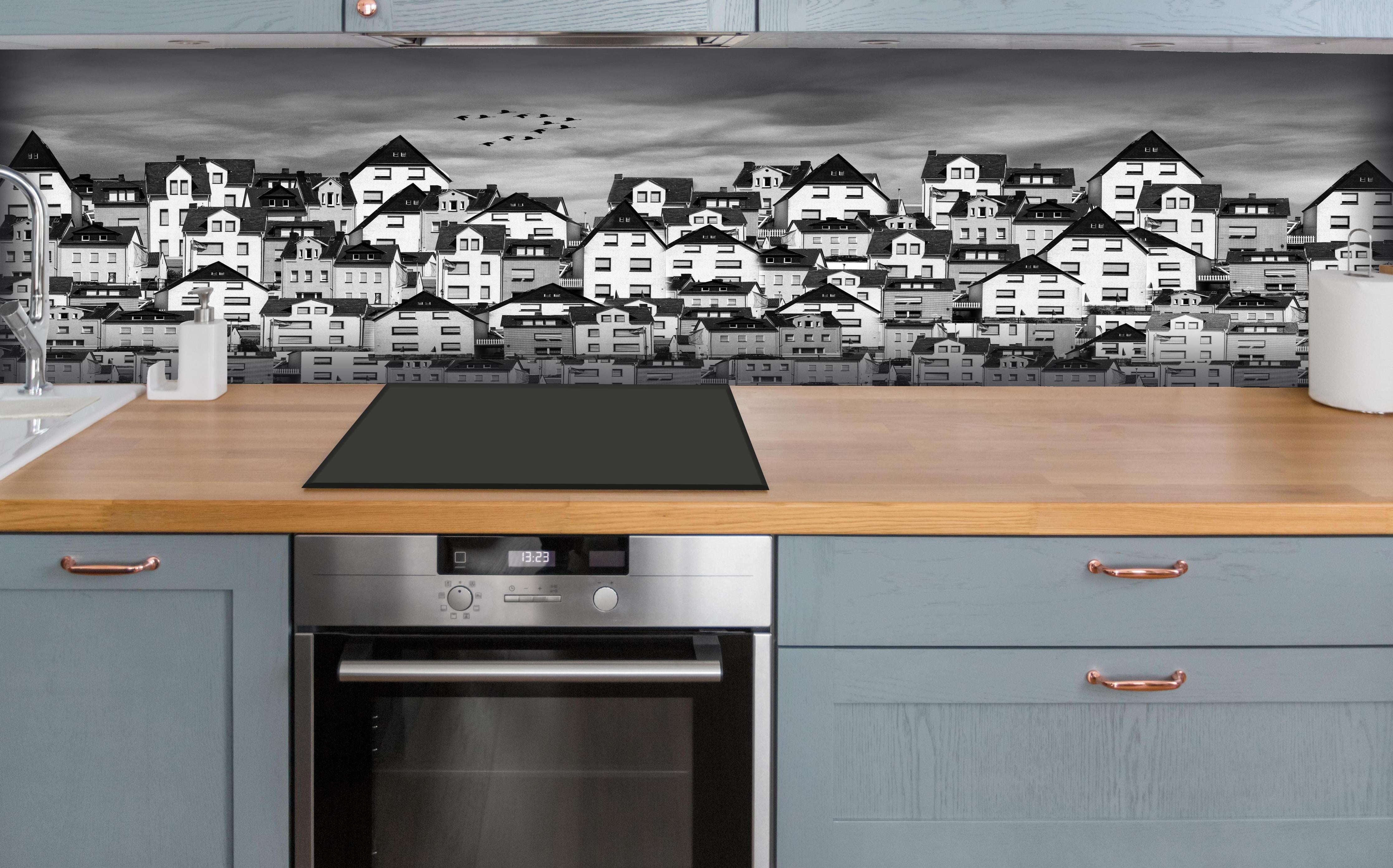 Küche - Schwarz-weiße Dachlandschaft mit Vögeln hinter weißen Hochglanz-Küchenregalen und schwarzem Wasserhahn