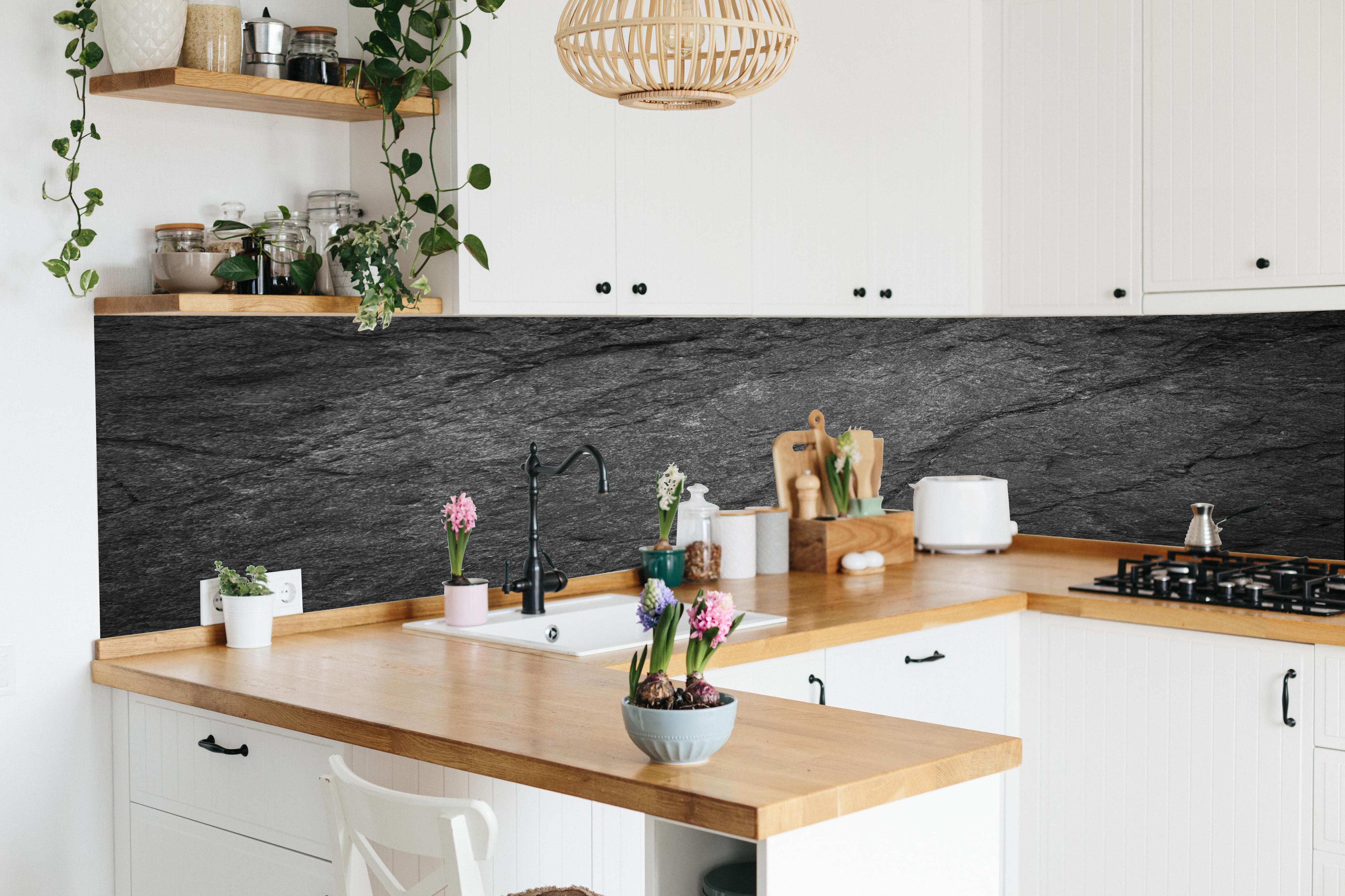 Küche - Schwarze Schieferplatte hinter weißen Hochglanz-Küchenregalen und schwarzem Wasserhahn