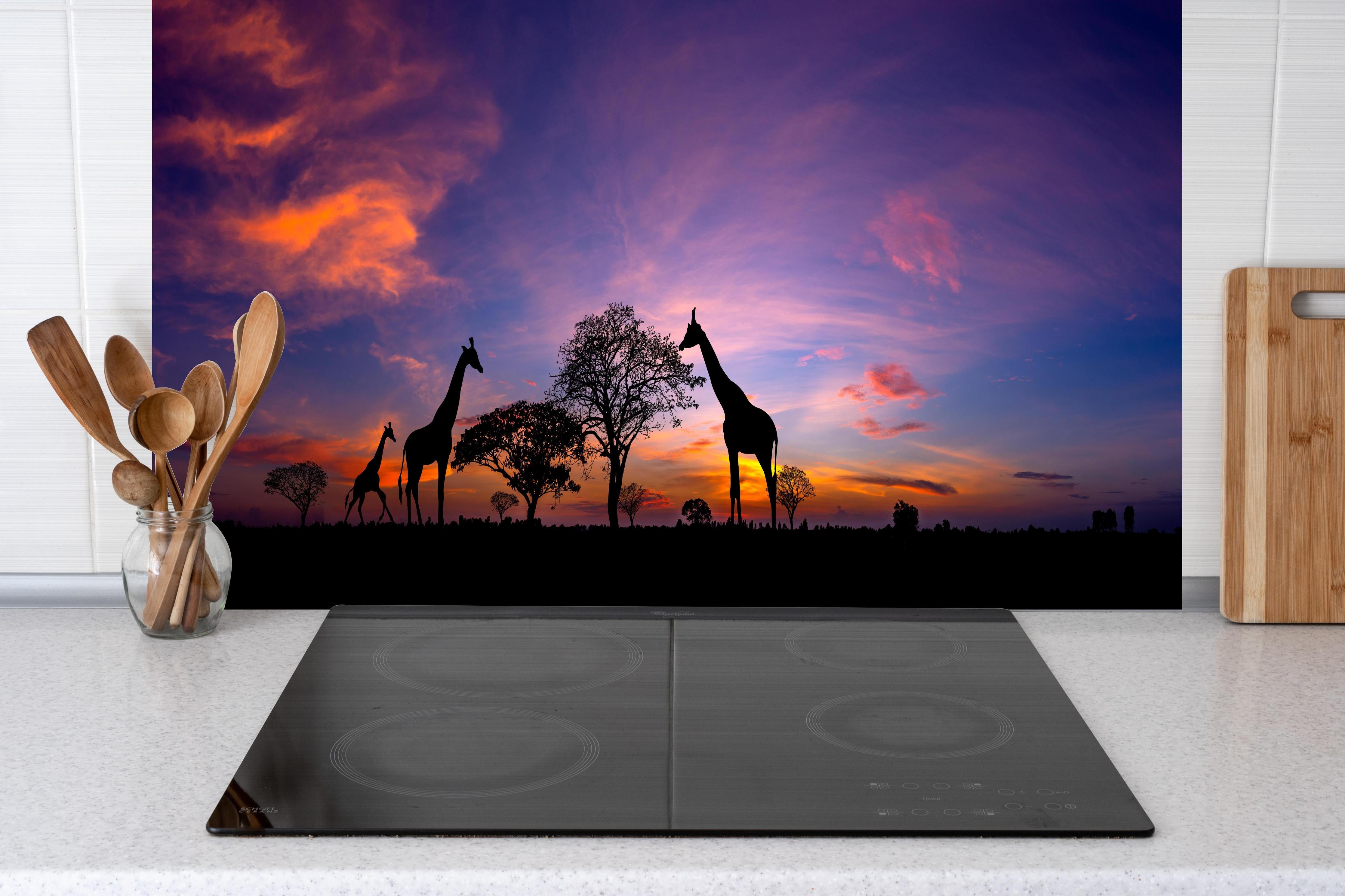 Küche - Silhouette - Giraffenfamilie bei Sonnenuntergang hinter weißen Hochglanz-Küchenregalen und schwarzem Wasserhahn
