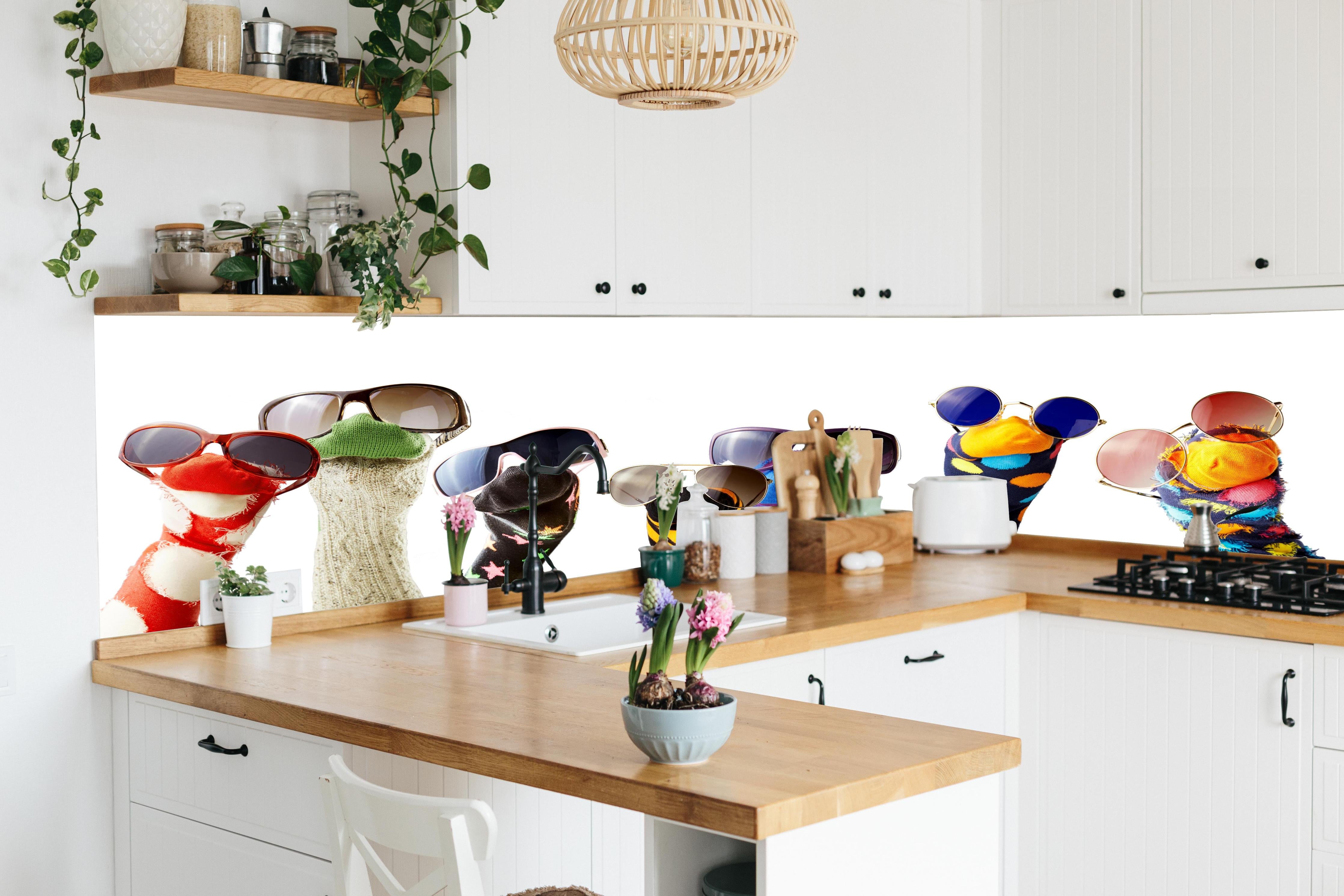 Küche - Sockenpuppen mit Brille hinter weißen Hochglanz-Küchenregalen und schwarzem Wasserhahn