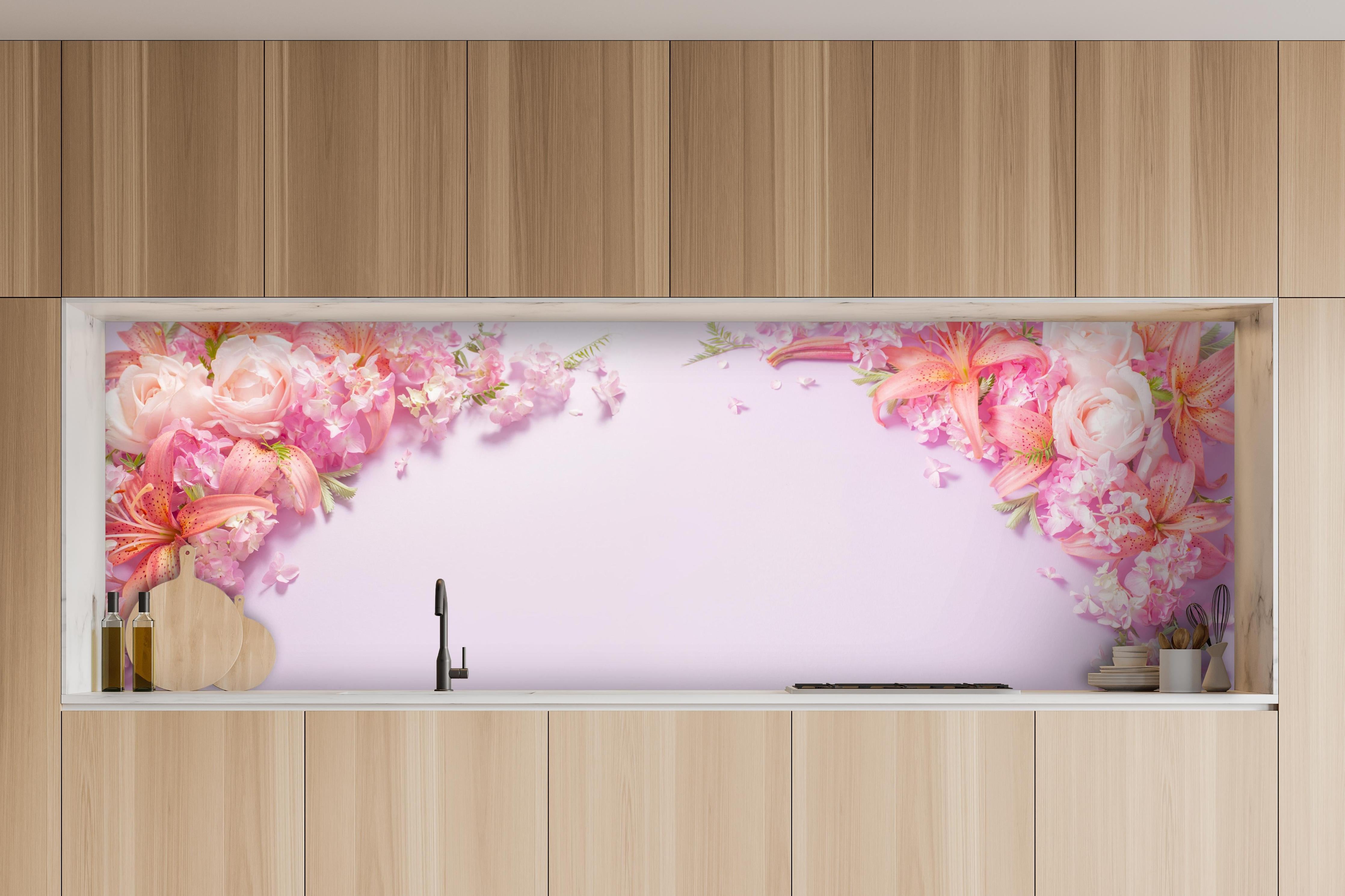Küche - Sommerliche Blumenarrangements auf Papier hinter weißen Hochglanz-Küchenregalen und schwarzem Wasserhahn