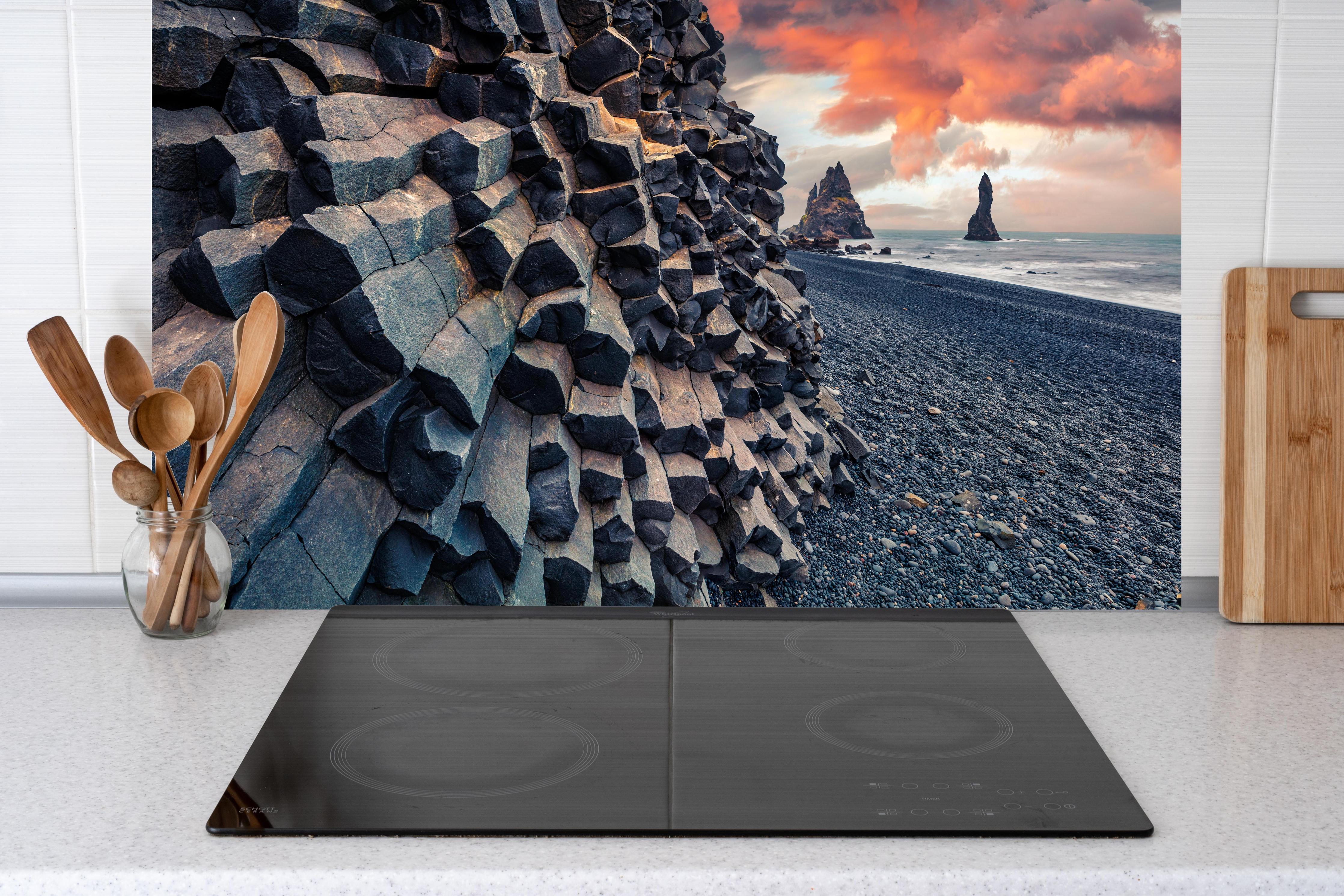 Küche - Sonnenuntergang - Reynisdrangar, Atlantischer Ozean hinter weißen Hochglanz-Küchenregalen und schwarzem Wasserhahn