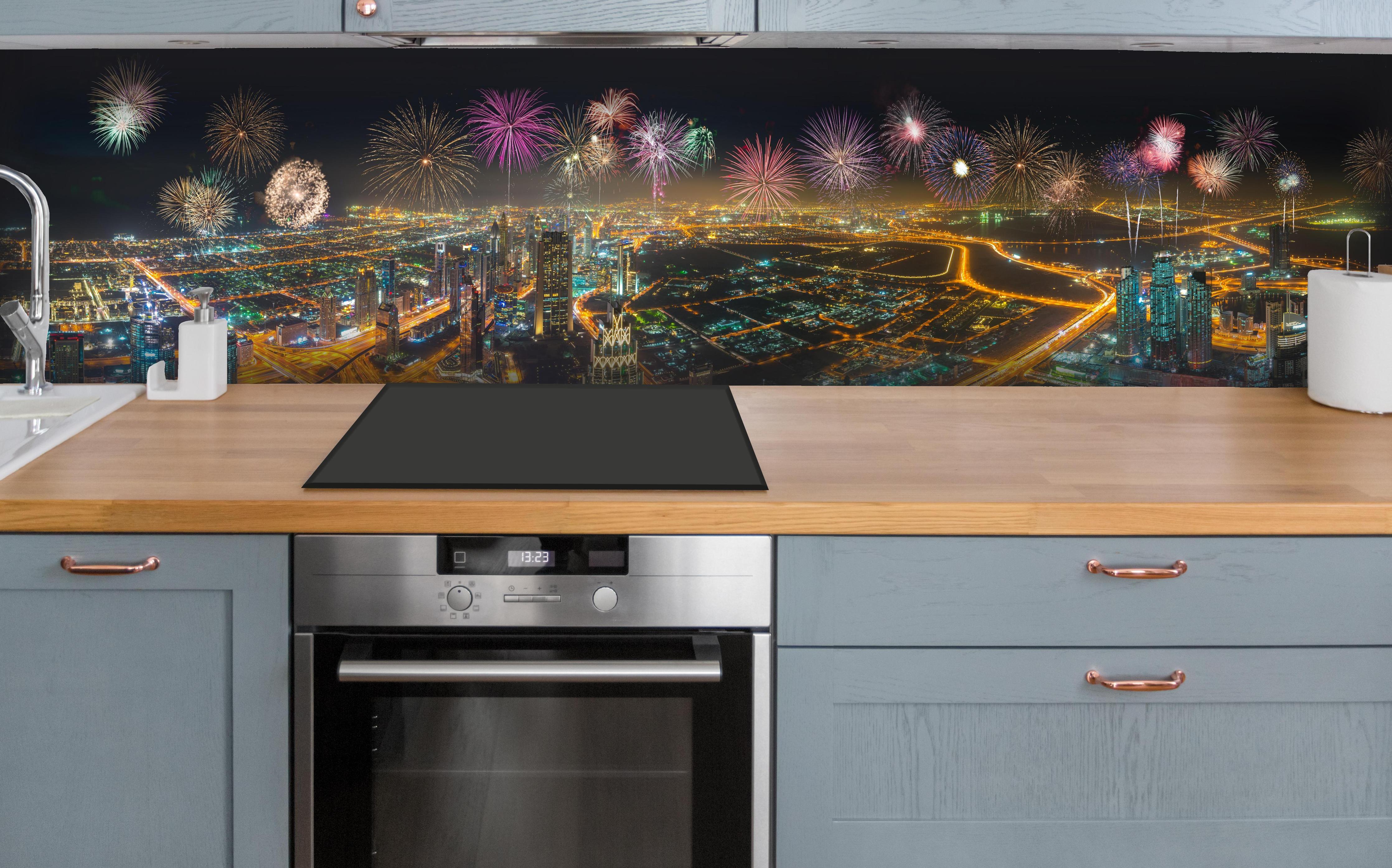 Küche - Spektakuläre Dubai Skyline mit Feuerwerk hinter weißen Hochglanz-Küchenregalen und schwarzem Wasserhahn