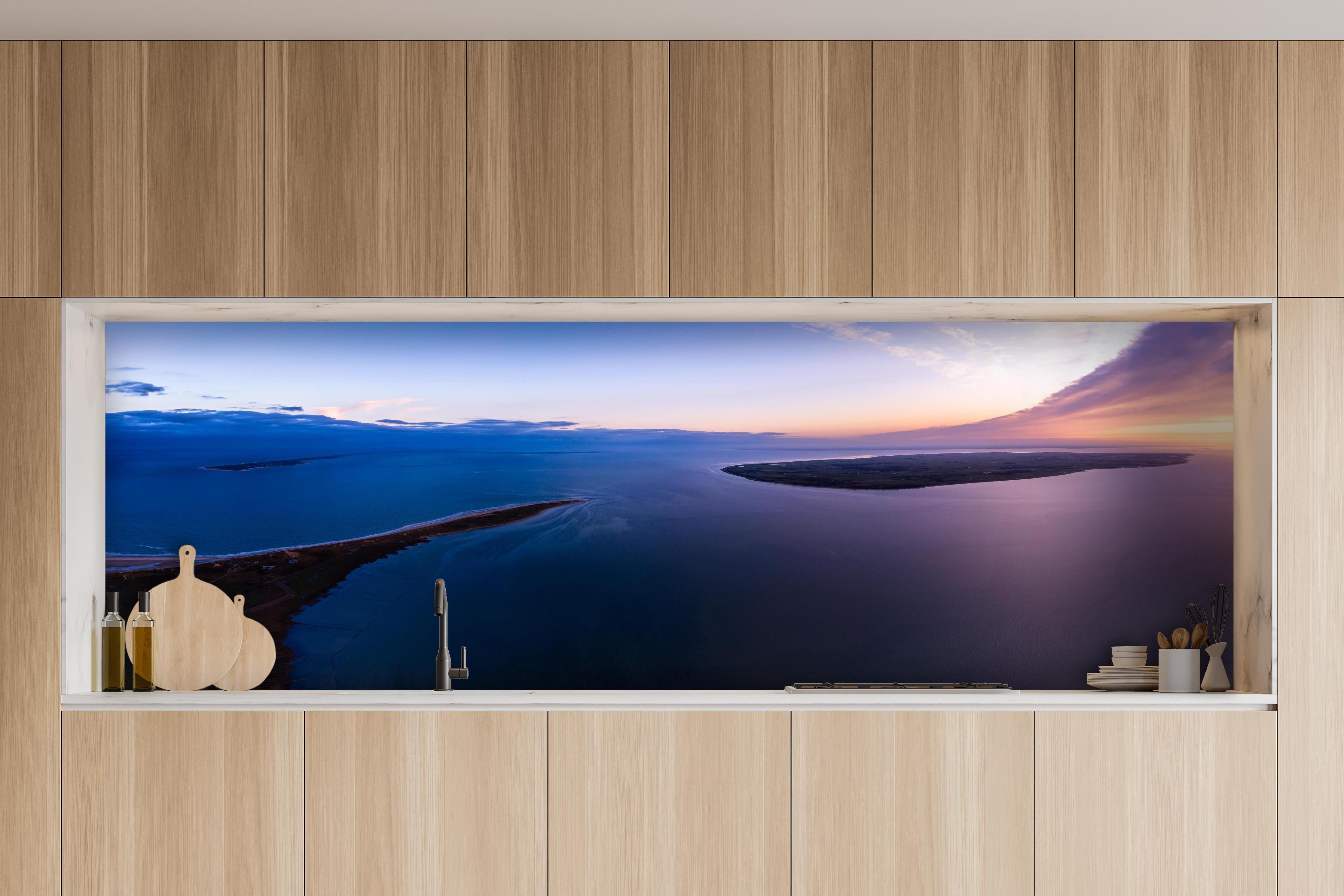 Küche - Spektakulärer Sonnenuntergang über ruhigem Gewässer und unberührten Inseln hinter weißen Hochglanz-Küchenregalen und schwarzem Wasserhahn